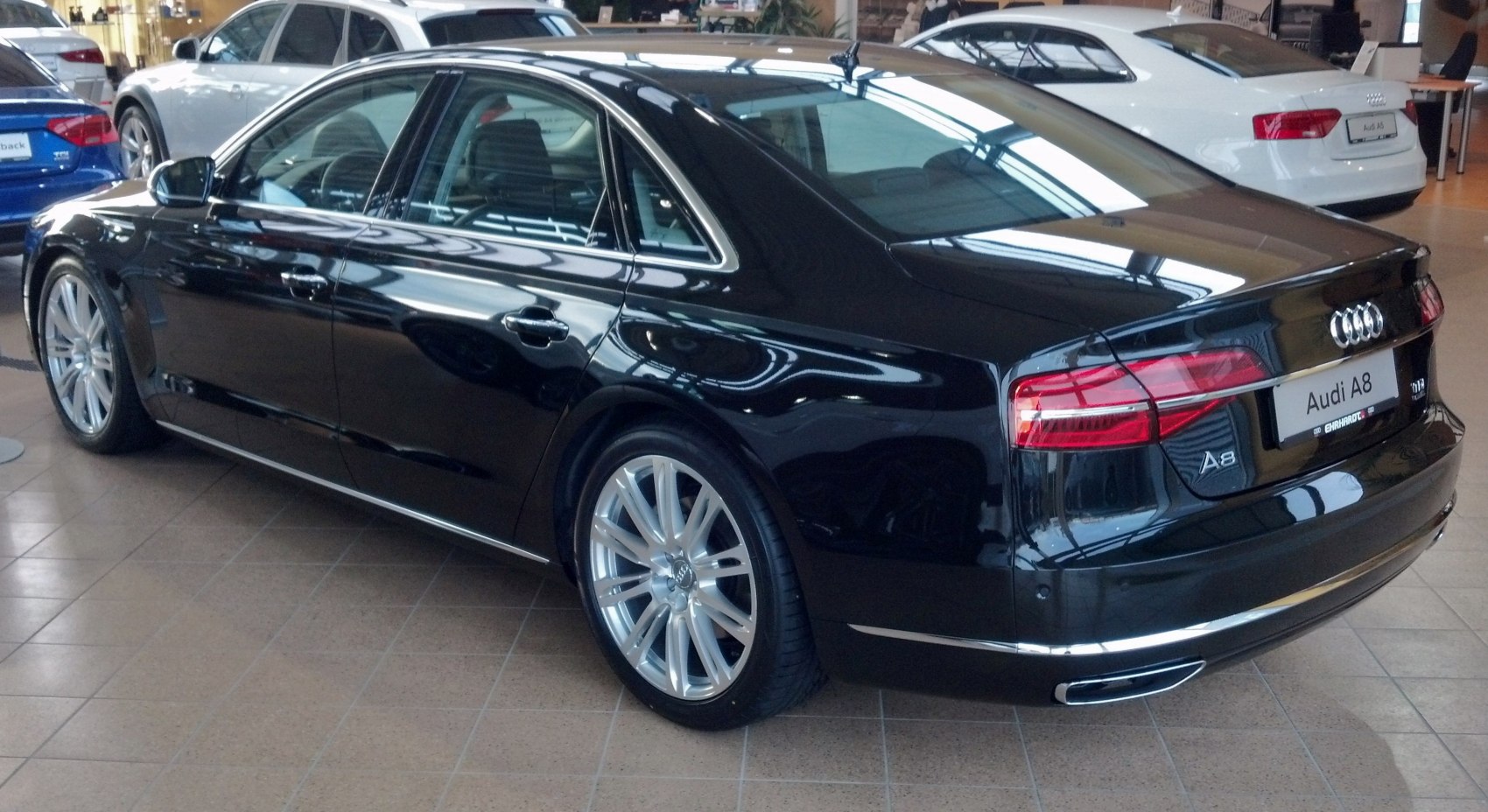 Rear and side view of black luxury sedan with alloy wheels and sleek taillights