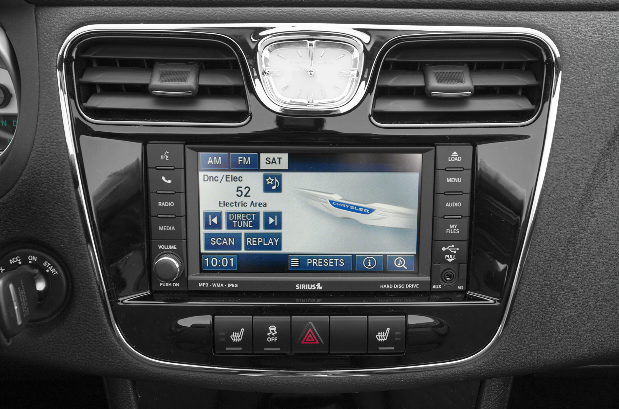 Infotainment display with radio and media controls, analog clock above