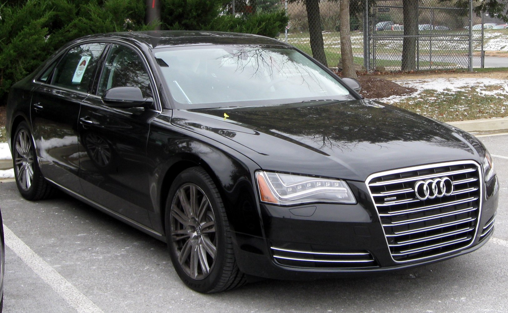 Front and side view of sedan with LED headlights and large grille