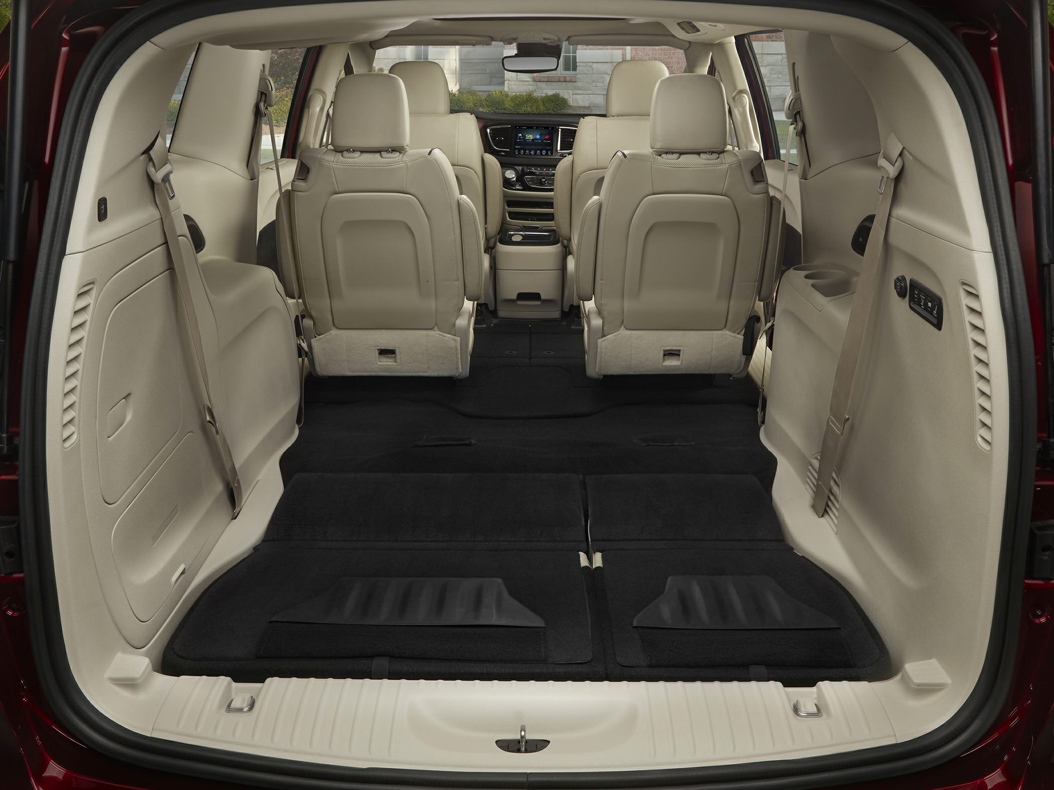 Folded third-row seats and spacious rear cargo area with beige interior.