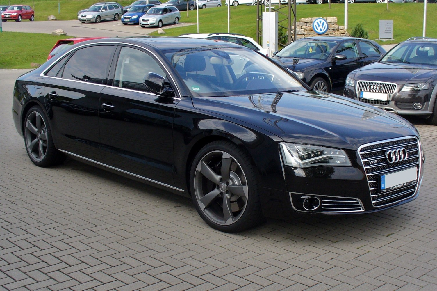 Luxury sedan front-left view with large alloy wheels and detailed grille