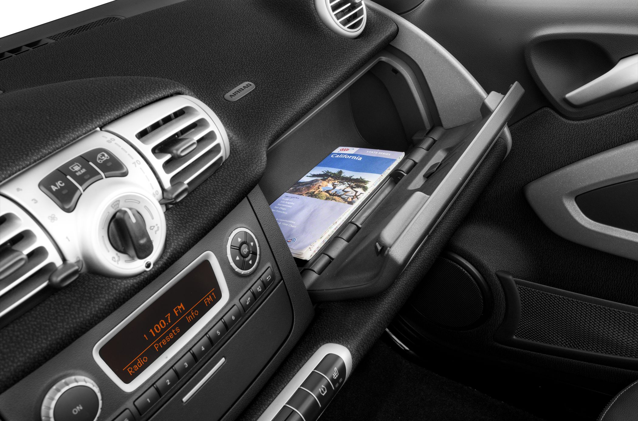Dashboard with radio and AC controls, open glovebox with map