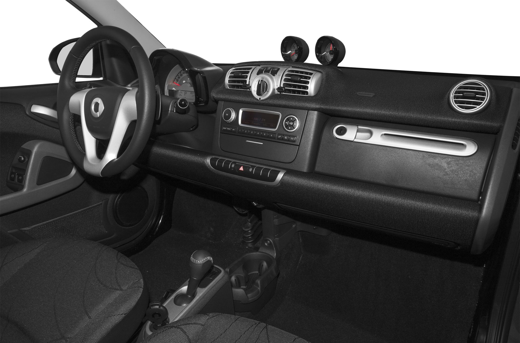 Dashboard and steering wheel with center-mounted gauges and audio system