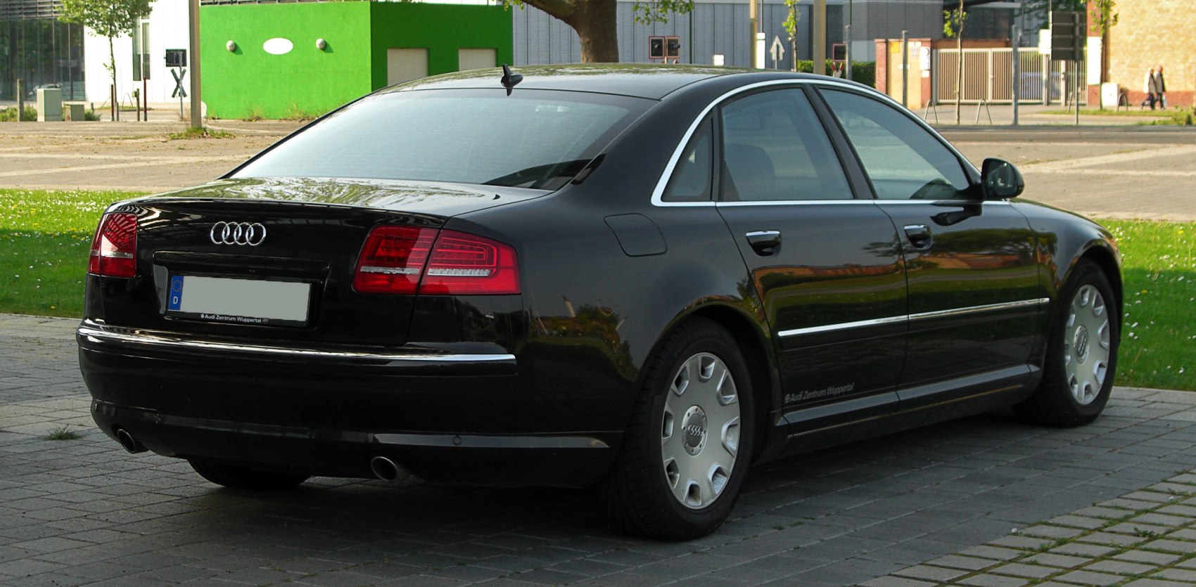 Rear side profile with taillights and chrome trim on a black luxury sedan