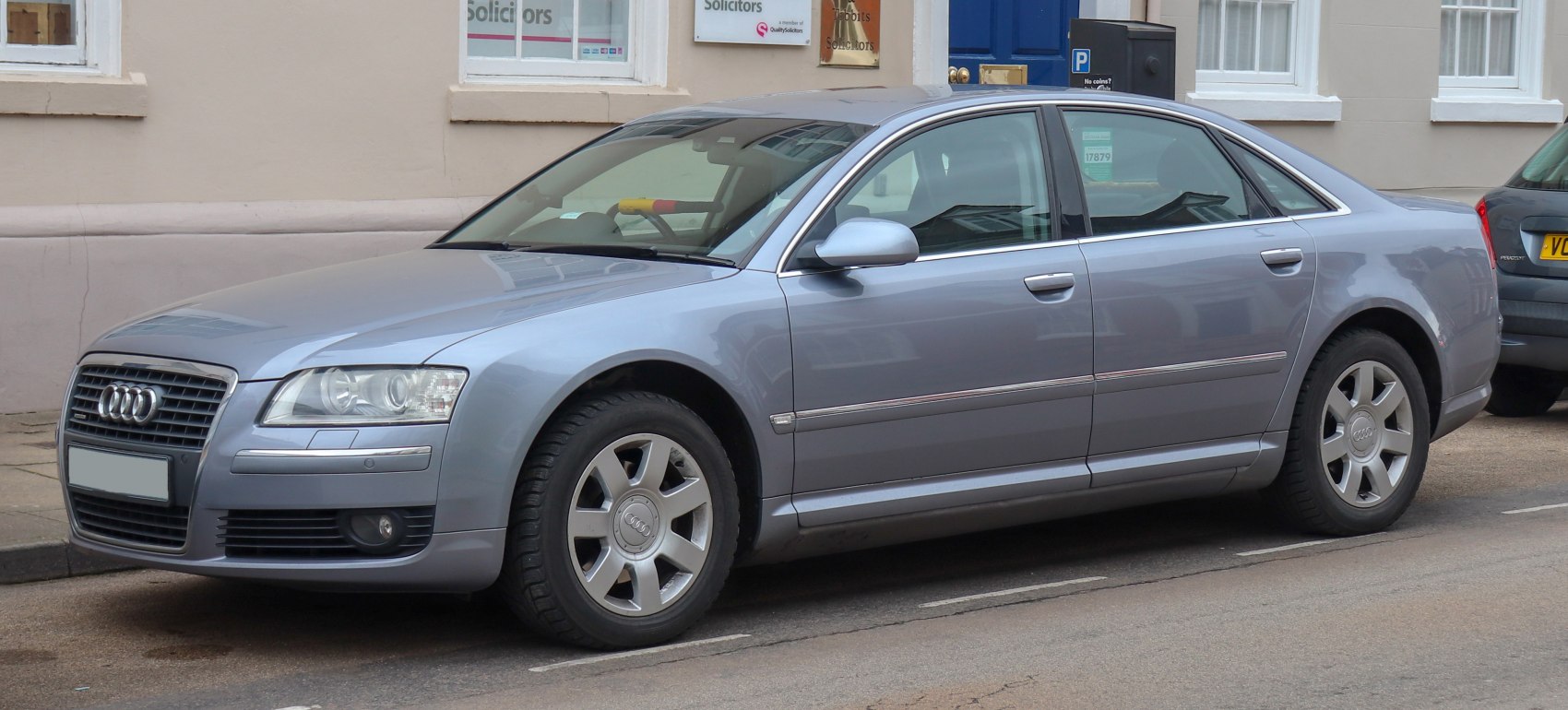 Silver sedan front side profile with alloy wheels and chrome trim