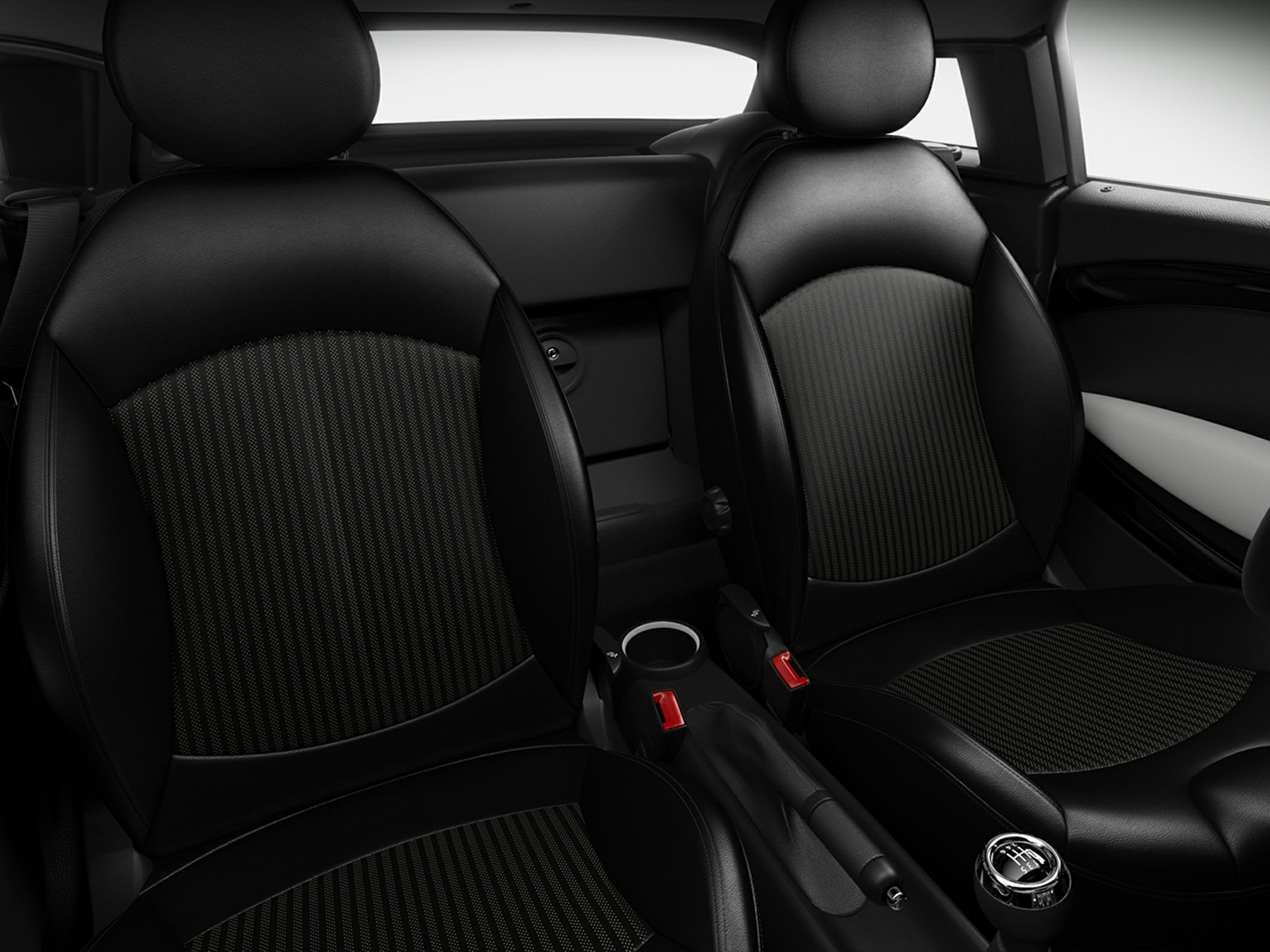 Front car seats with black upholstery and manual gear shift lever.