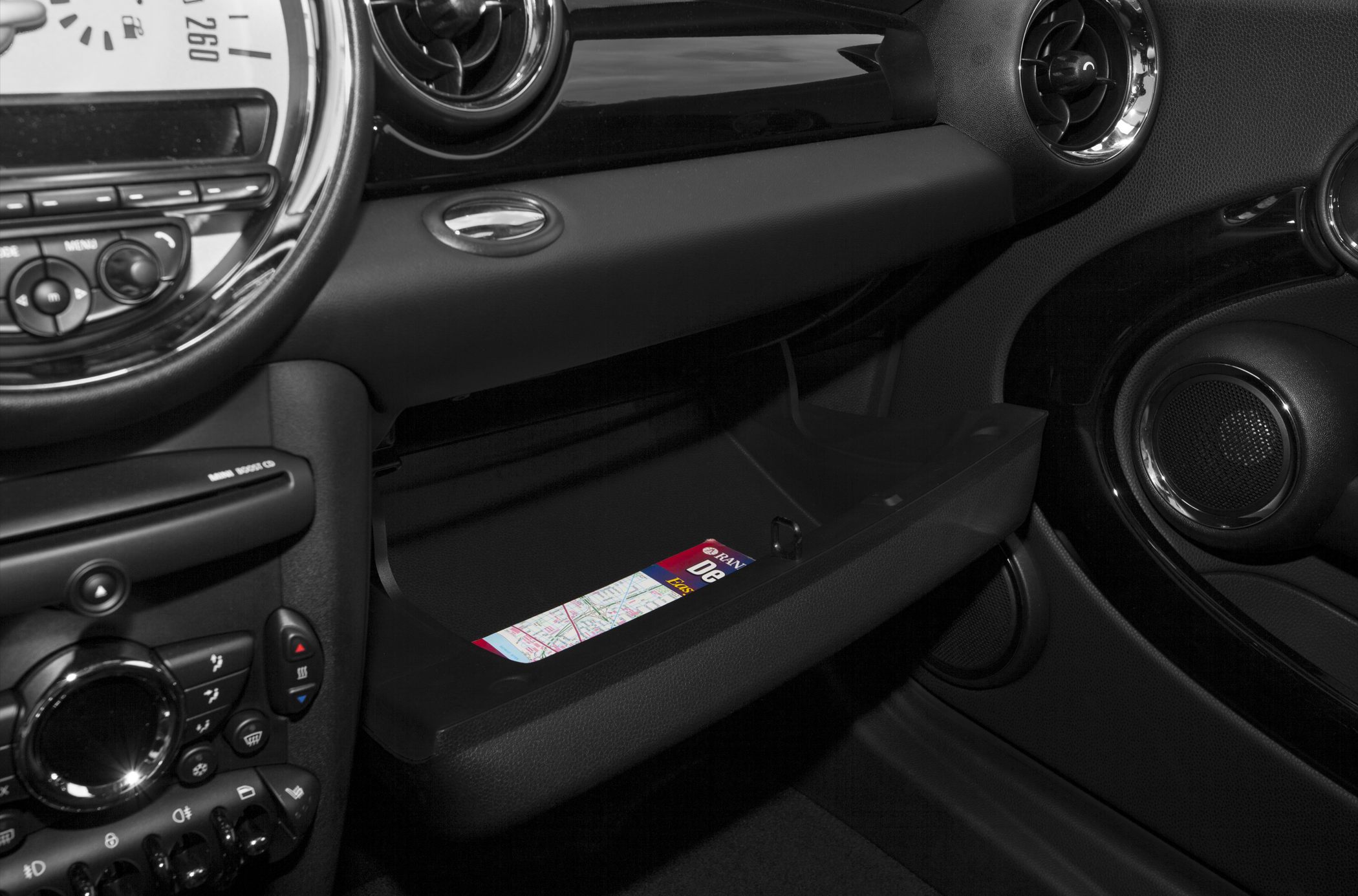 Dashboard with circular vents and open glovebox showing map inside