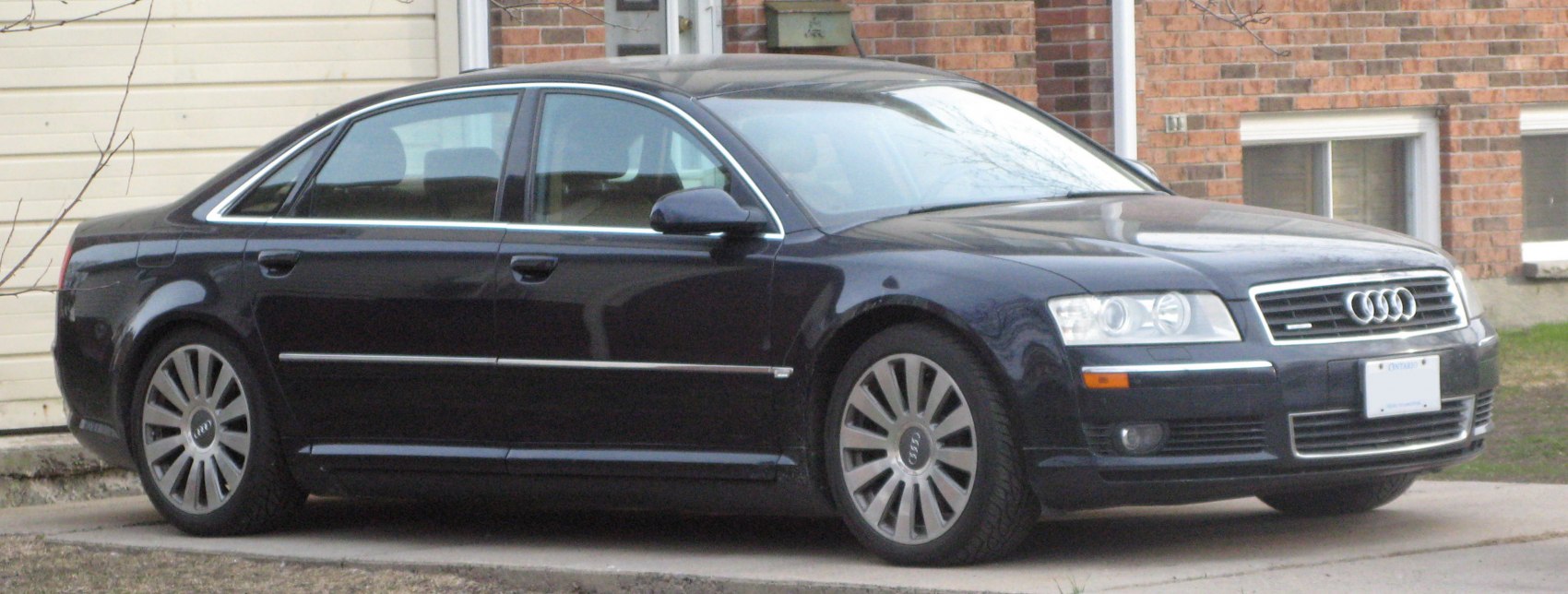 Front side view of luxury sedan with distinct headlights and grille