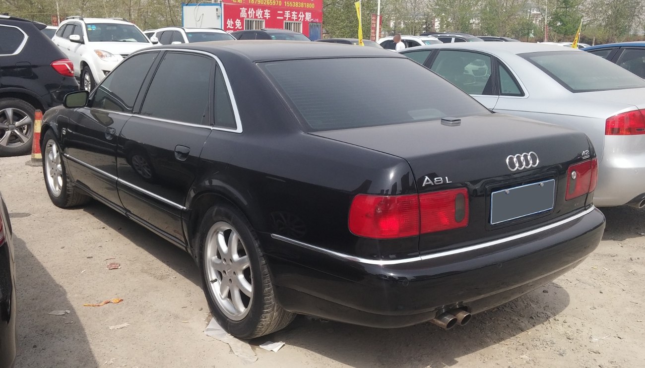 Rear view of a black luxury sedan with dual exhaust and rectangular taillights