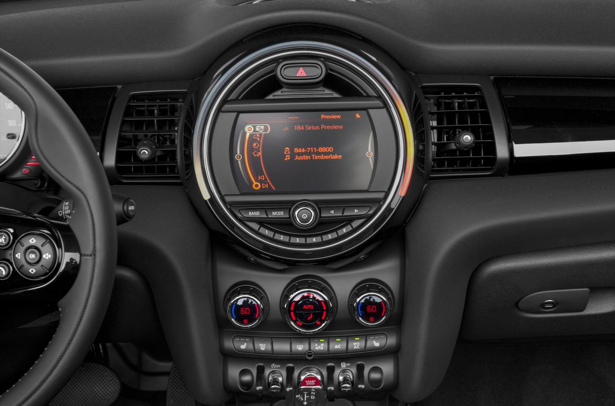 Round central infotainment display with climate control dials and toggle switches