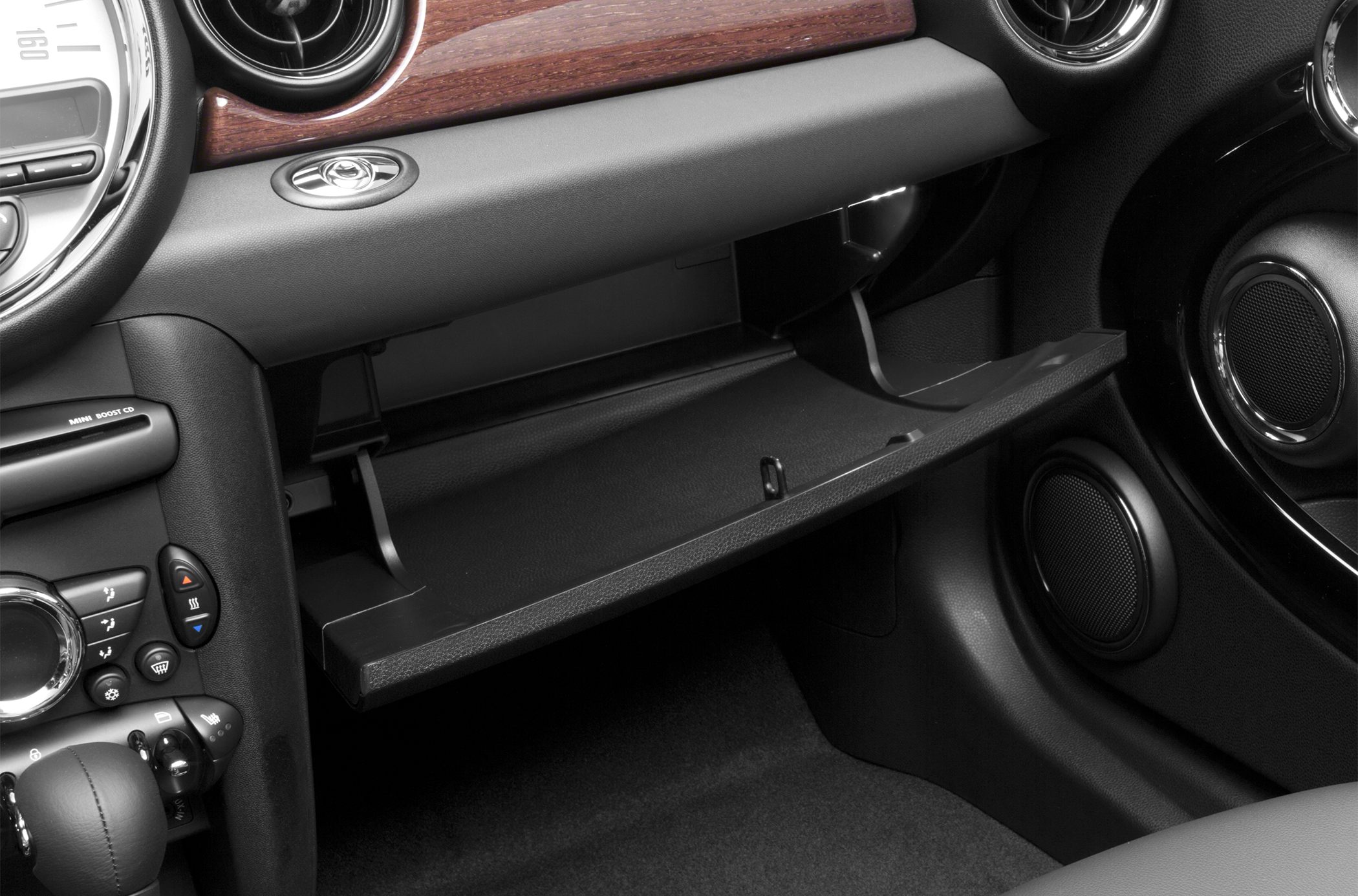 Open glovebox and center console controls with circular air vents.