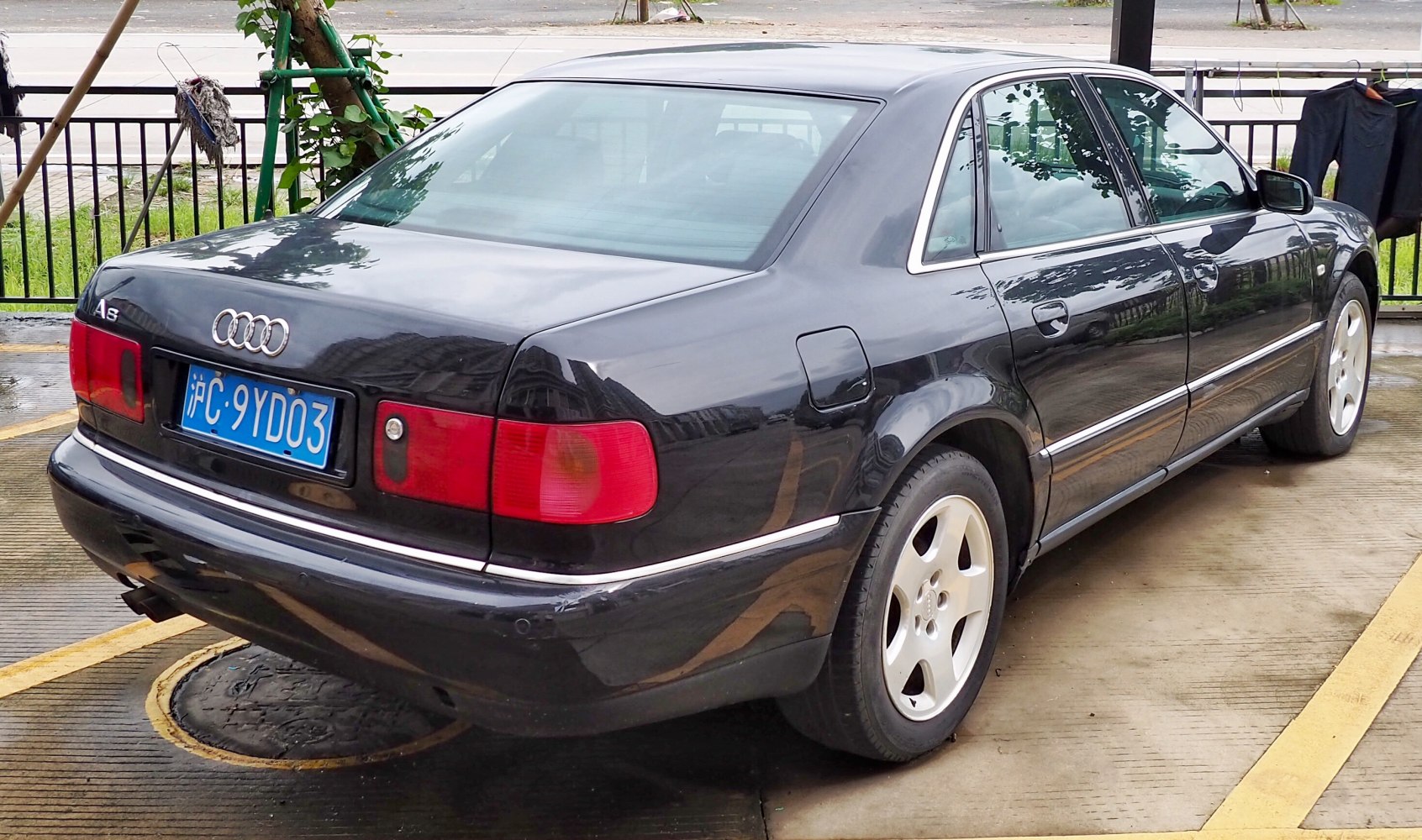 Rear three-quarter view of a classic luxury sedan with distinctive taillights and alloy wheels.