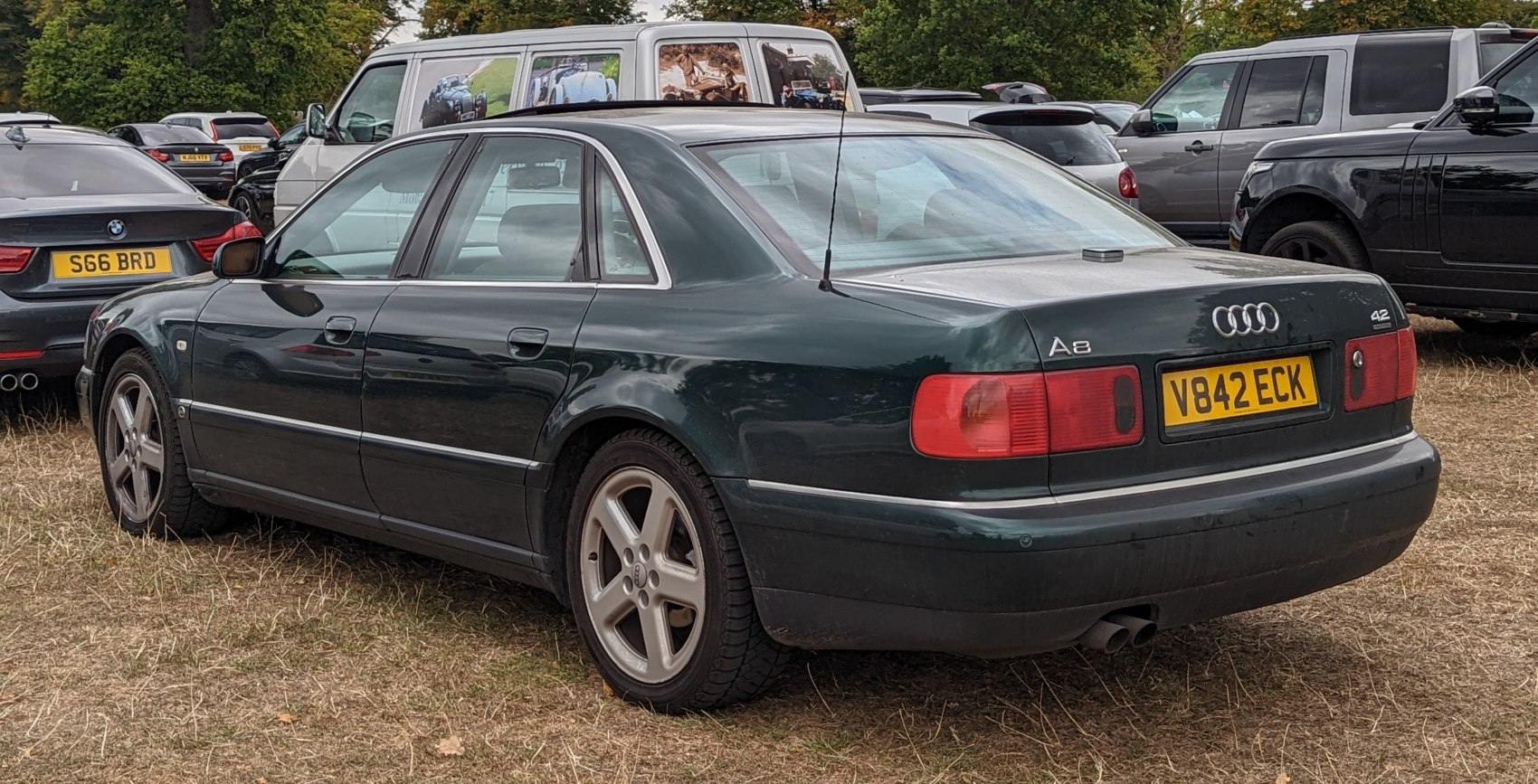 Rear side view of a classic executive sedan with alloy wheels and distinctive taillights