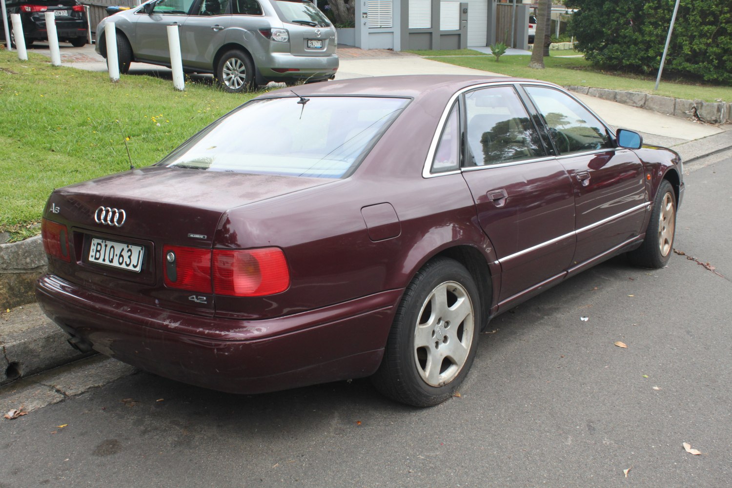 Classic sedan rear and side view with alloy wheels and tinted windows