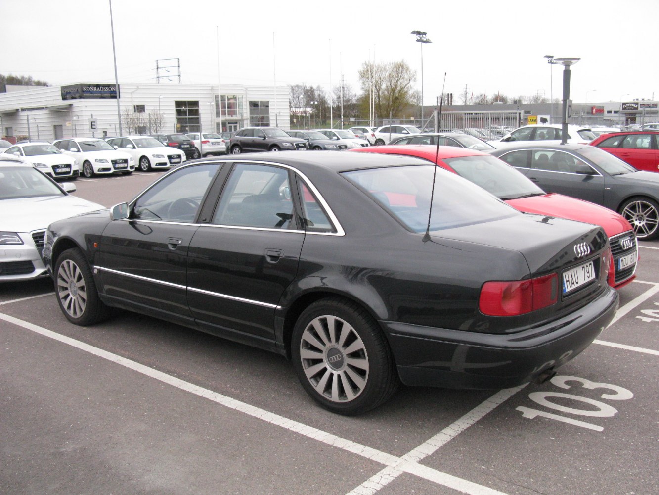 Black sedan with rear side view featuring alloy wheels and classic design