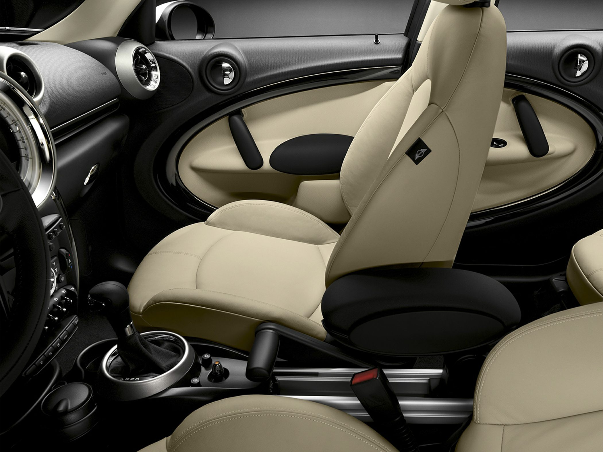 Beige leather seats and detailed interior door panel with manual gear shifter.