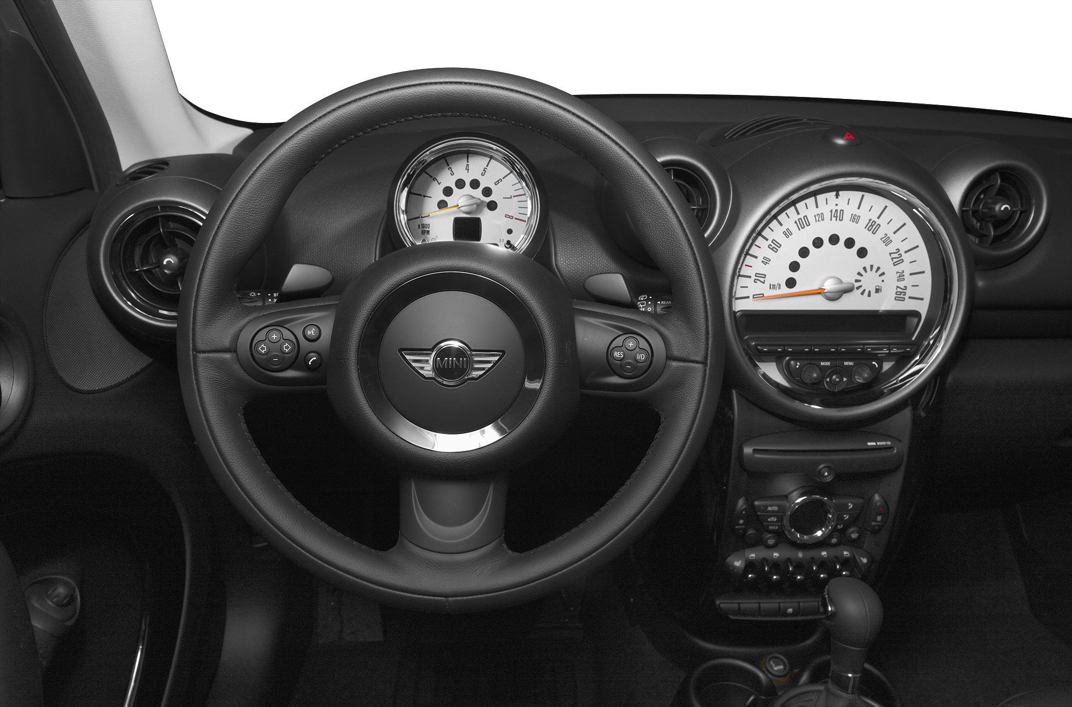 Steering wheel with central logo and classic round speedometer.