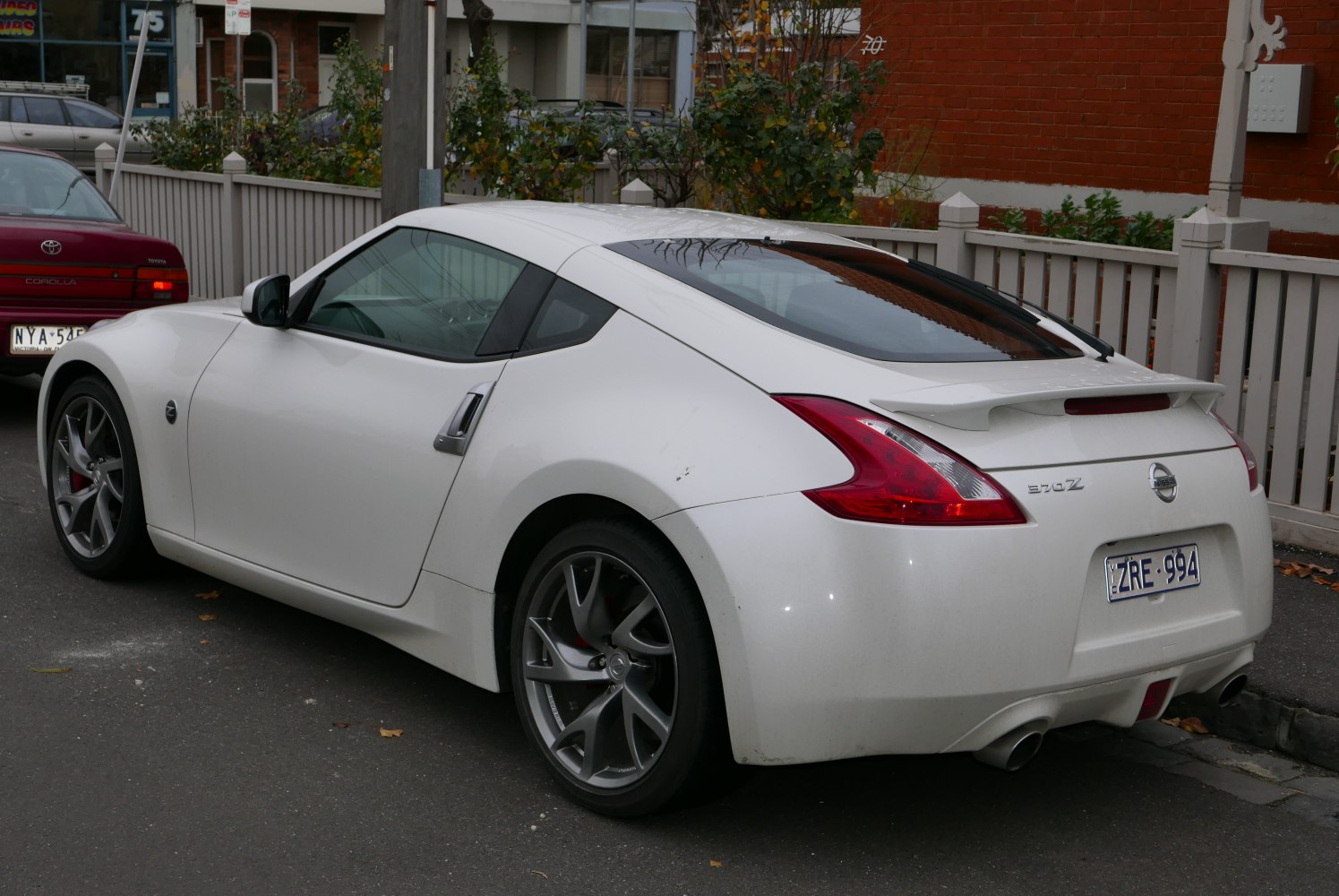 Side and rear view of a sporty coupe with rear spoiler and alloy wheels