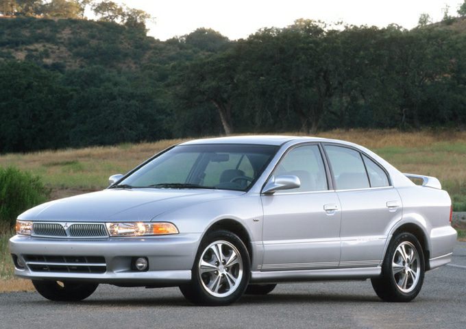 Silver sedan with alloy wheels and rear spoiler parked outdoors