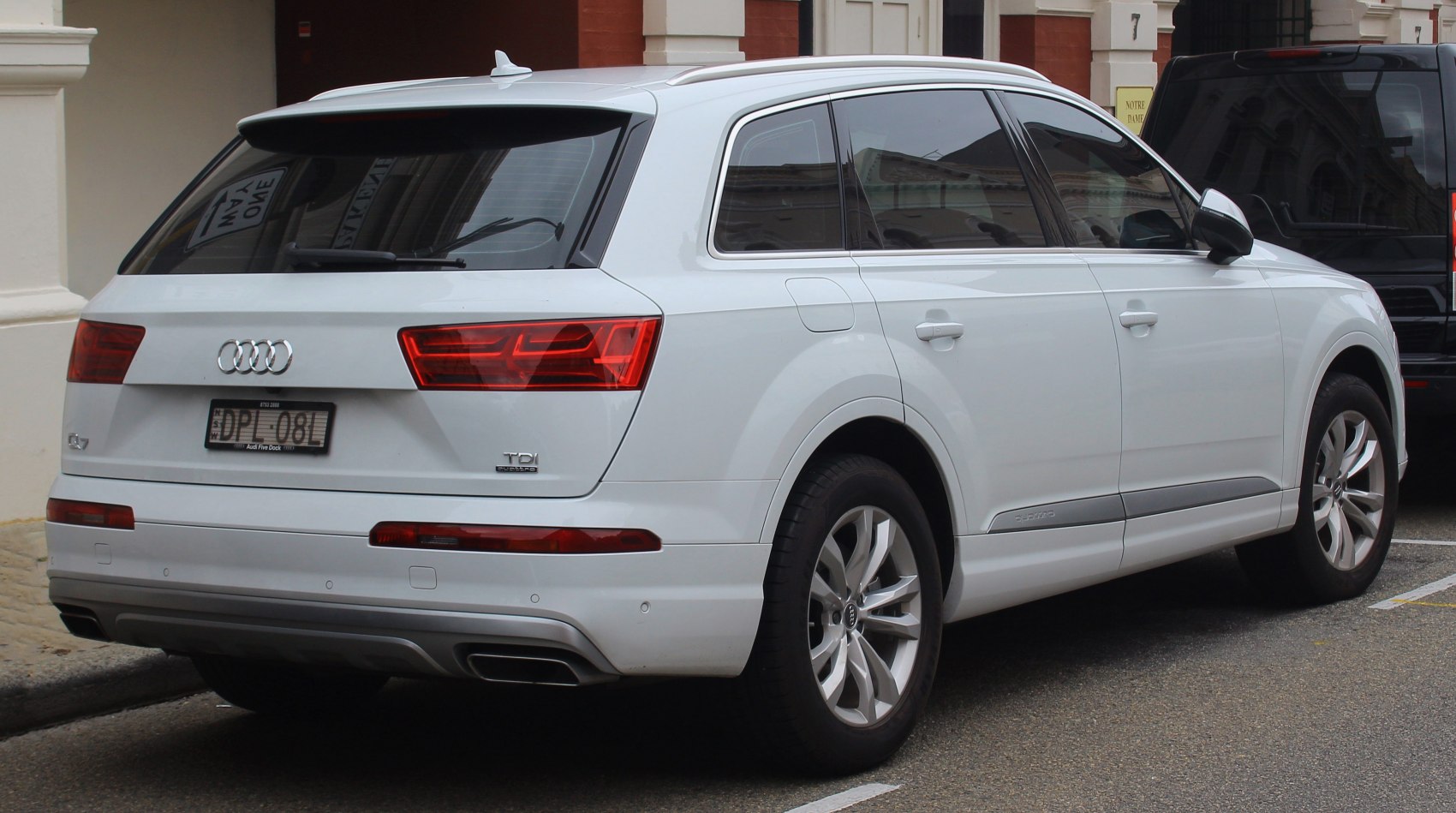 White luxury SUV rear side with LED tail lights and dual exhaust.