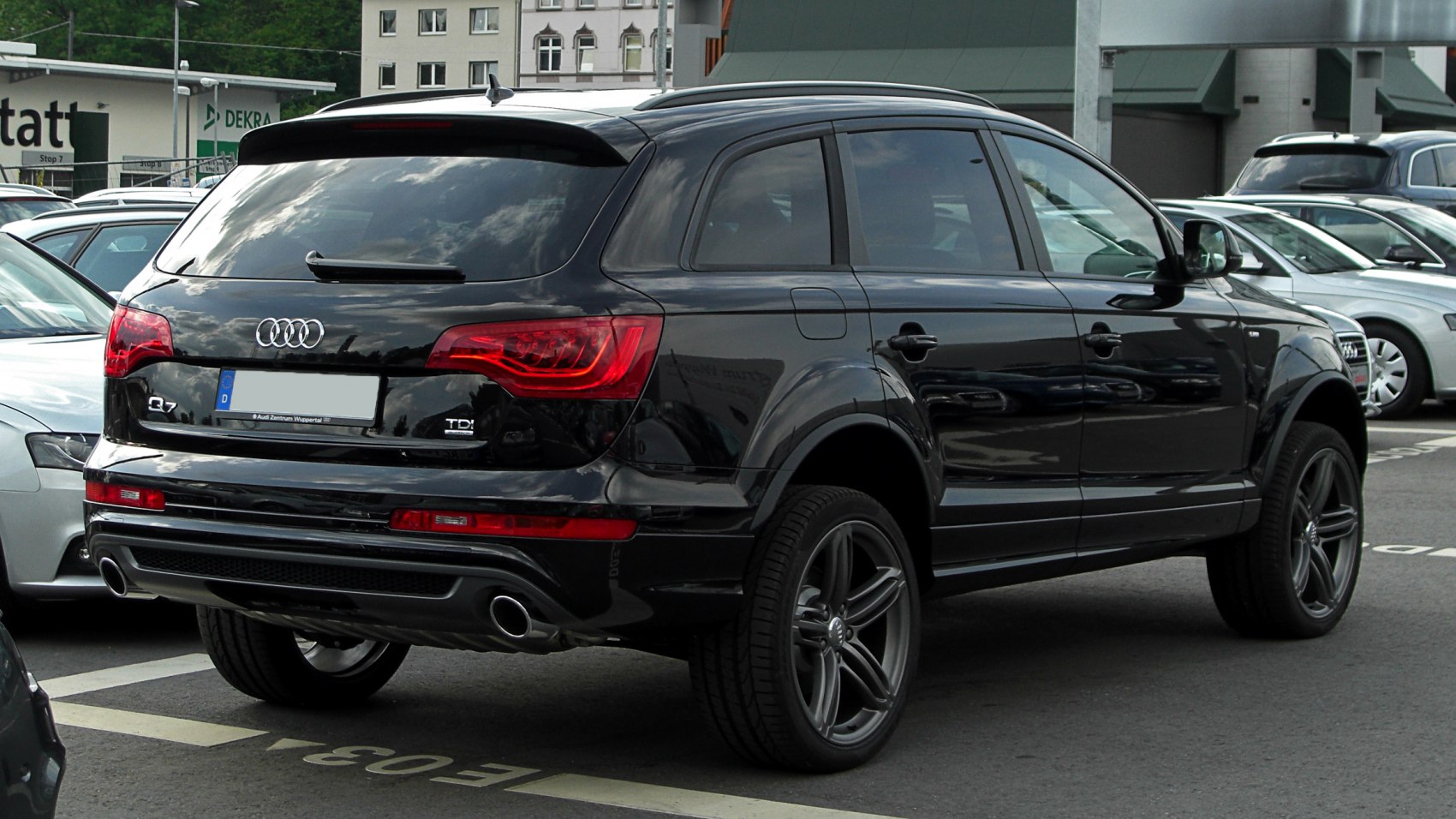 Rear and side view of a black SUV with dual exhausts and tinted windows