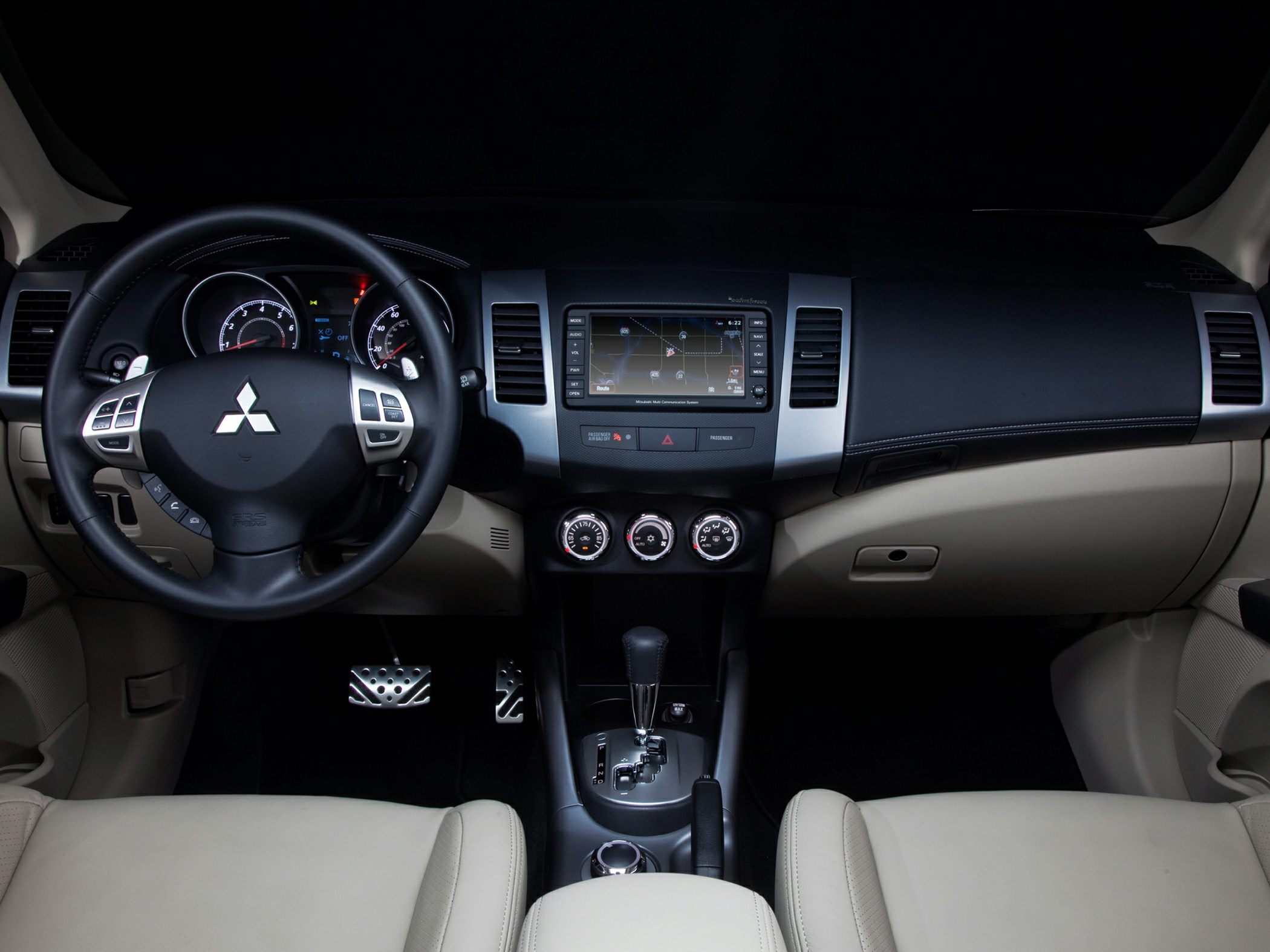Interior dashboard with steering wheel, touchscreen navigation, and climate control dials