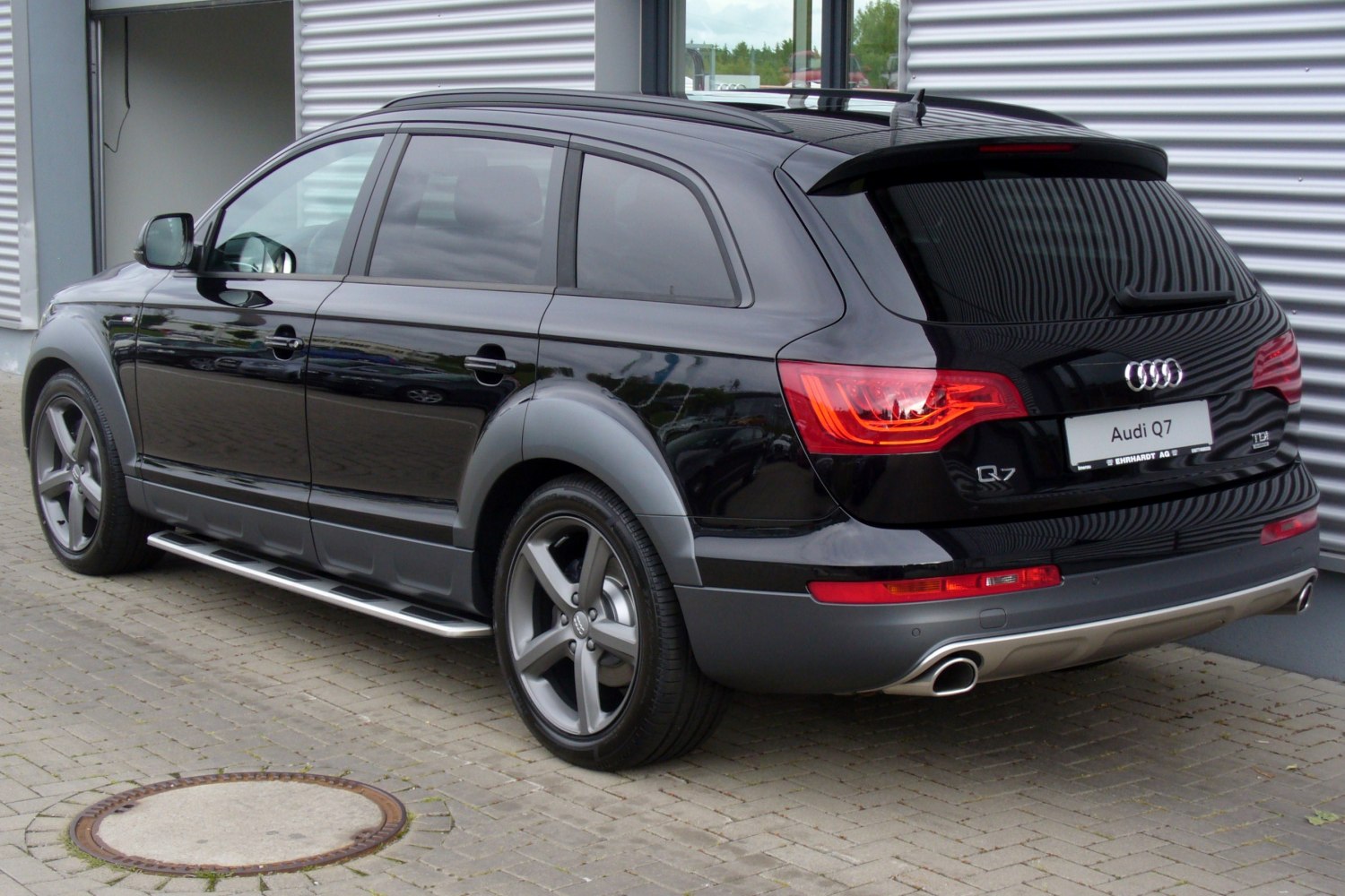 Rear side view of black SUV with alloy wheels and dual exhausts