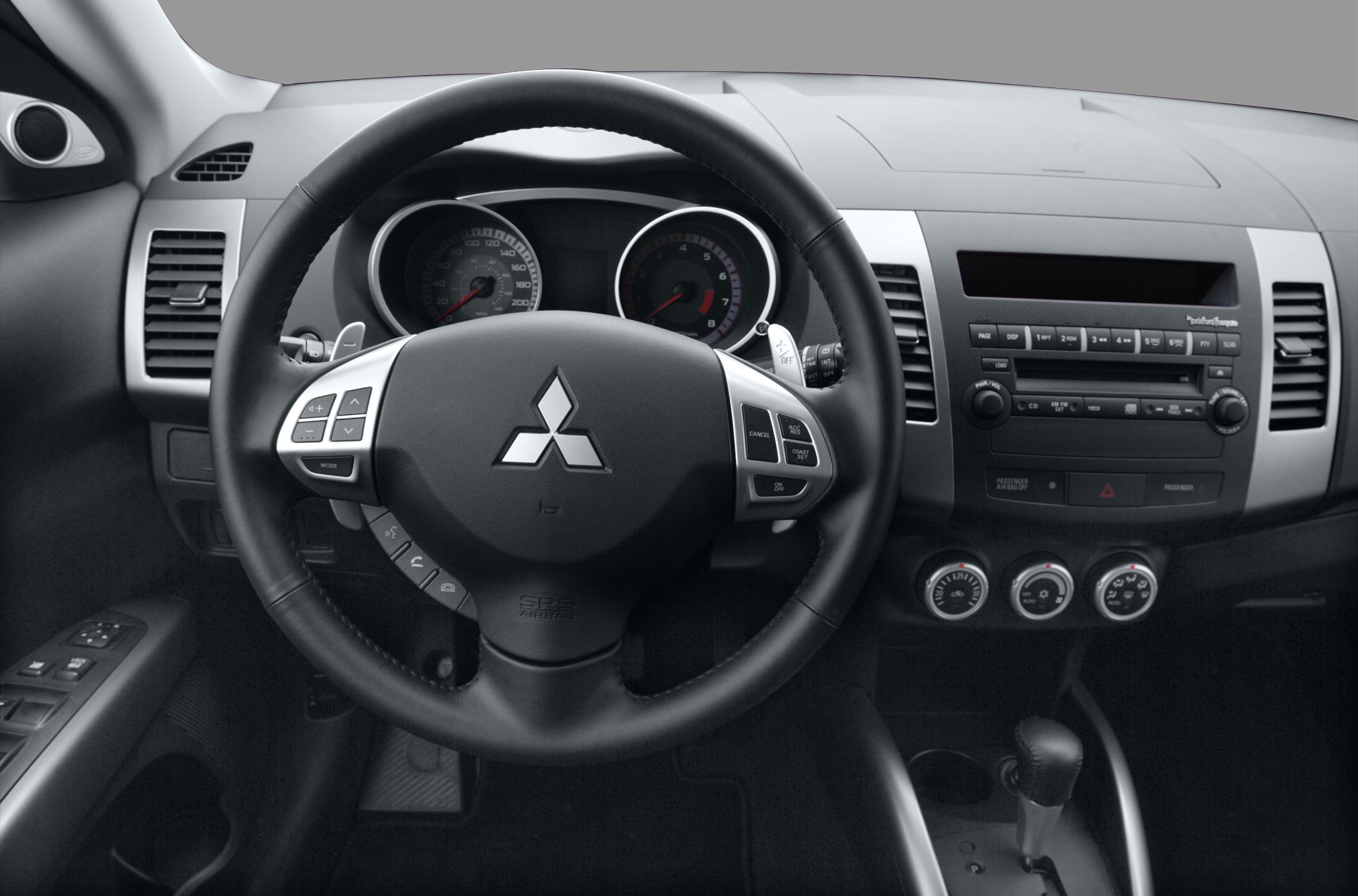 Steering wheel with controls and dashboard with instrument cluster and audio system