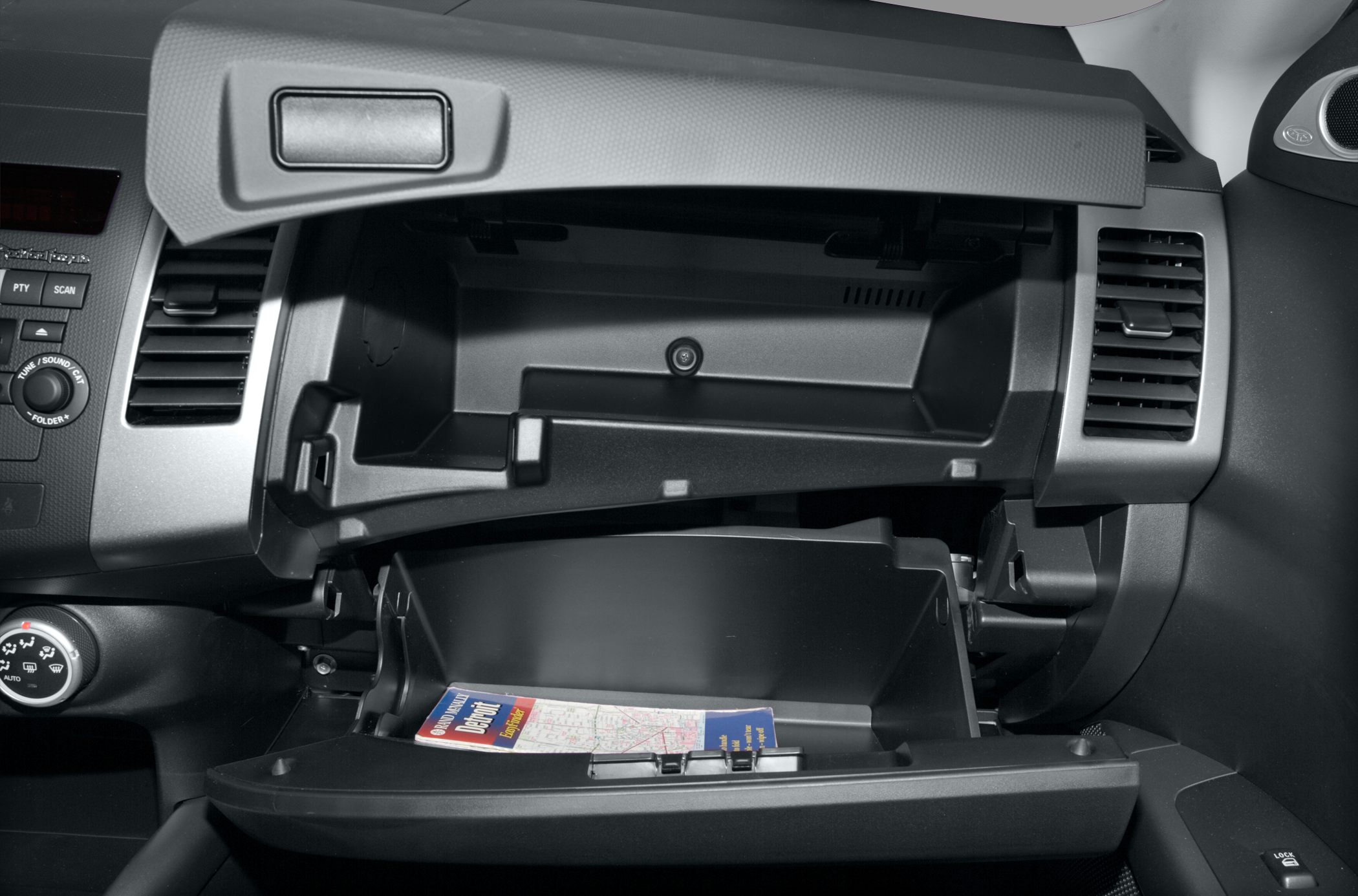 Dual glove box compartments with one containing a map booklet