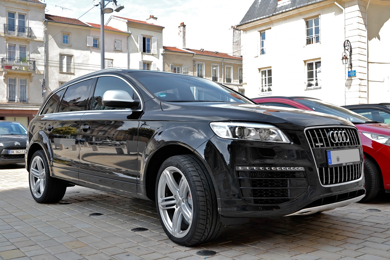 Front-side view of black SUV with LED daytime running lights and V12 badge.
