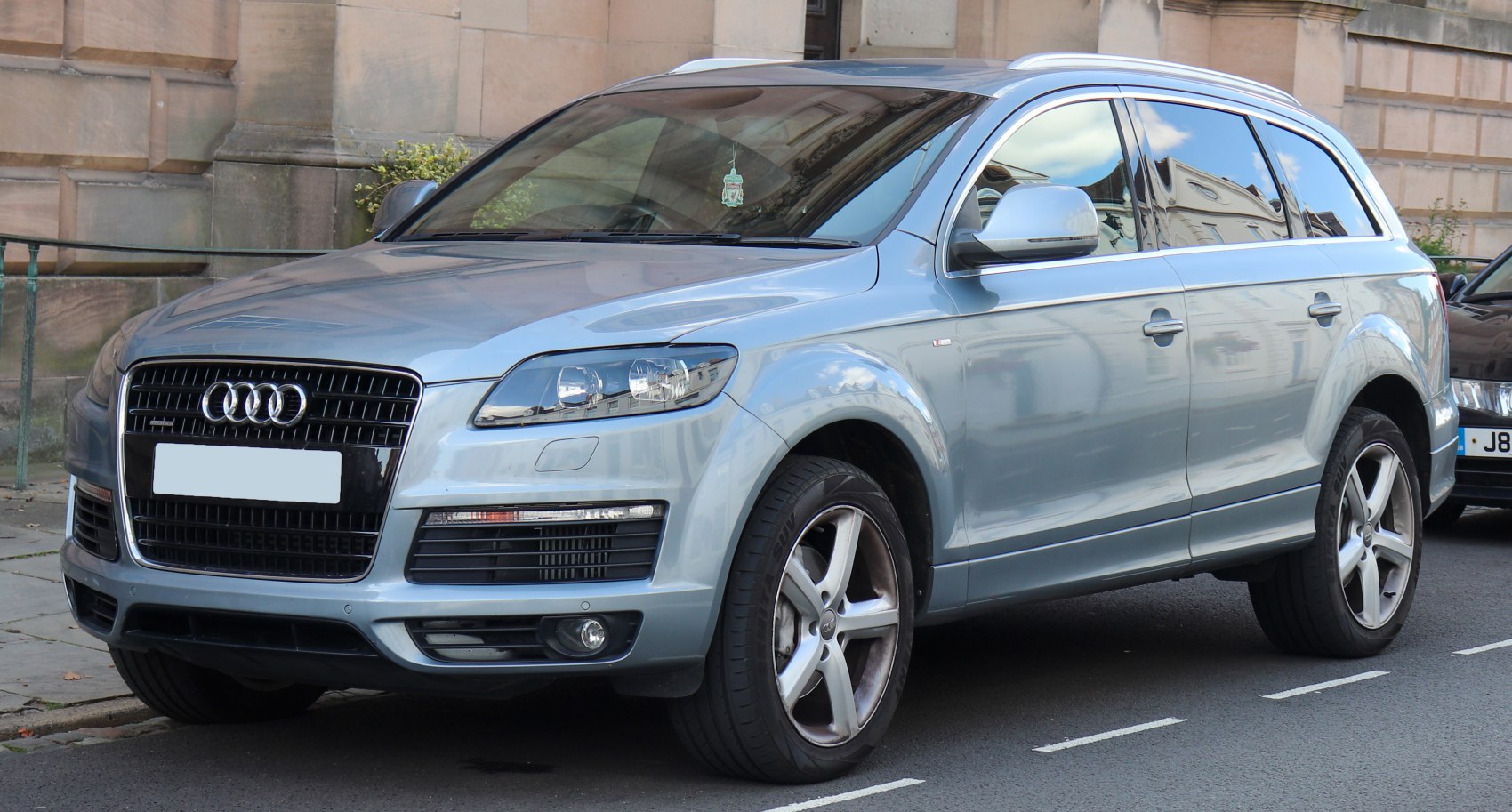 Front side angle of silver luxury SUV showing headlights and alloy wheels