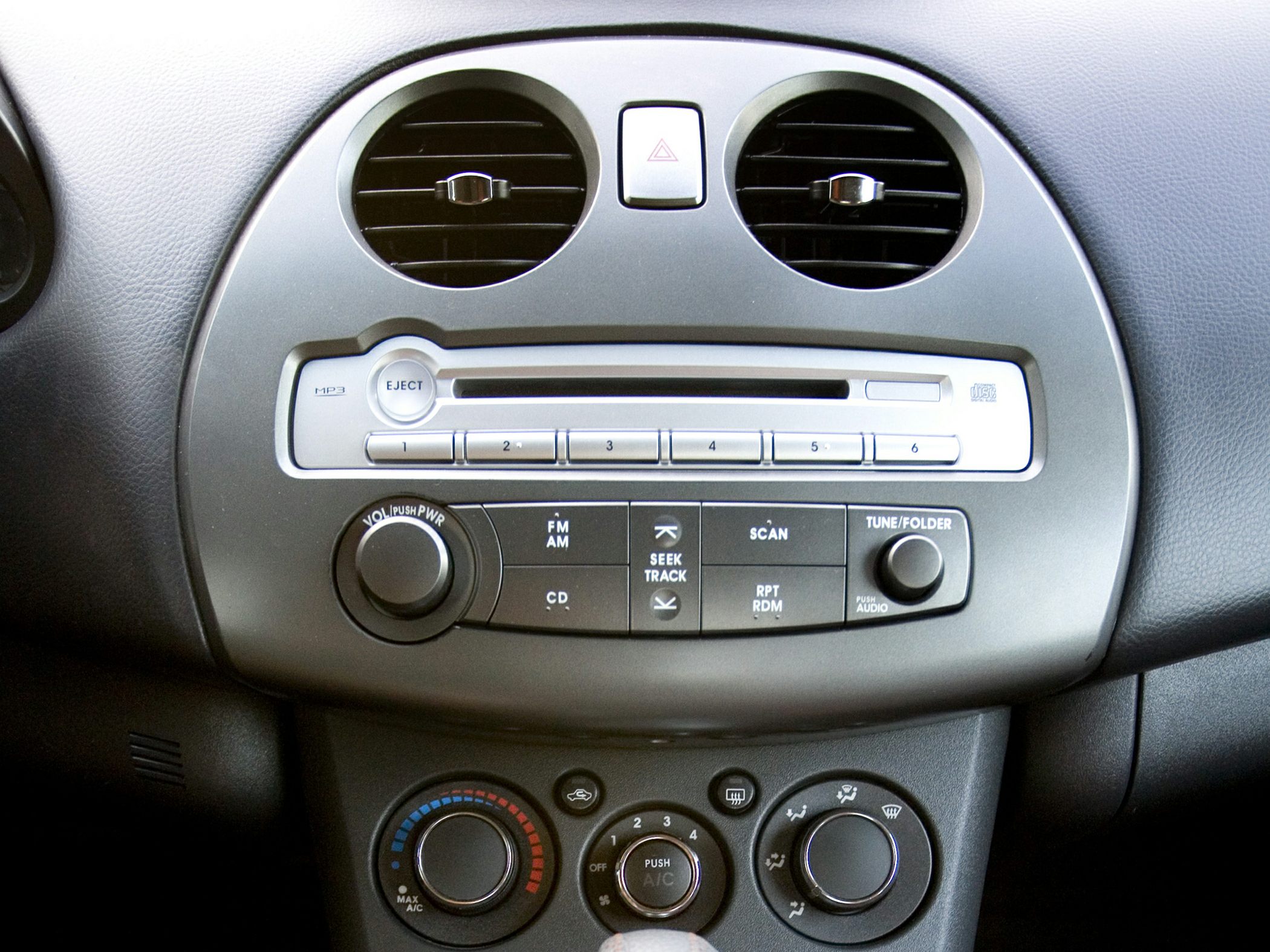 Car dashboard radio and climate control panel with vents.