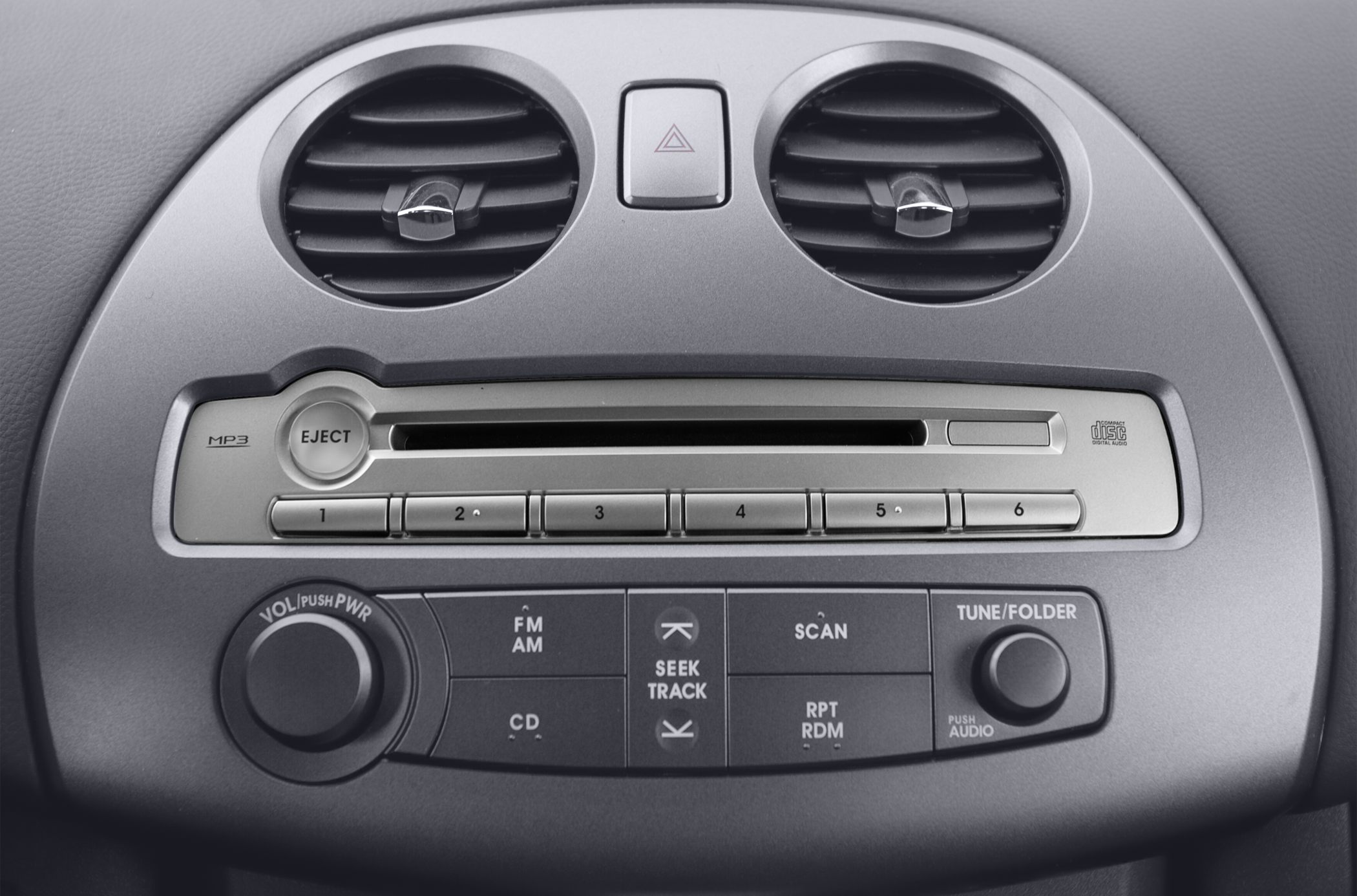 Close-up of car dashboard air vents and audio control panel