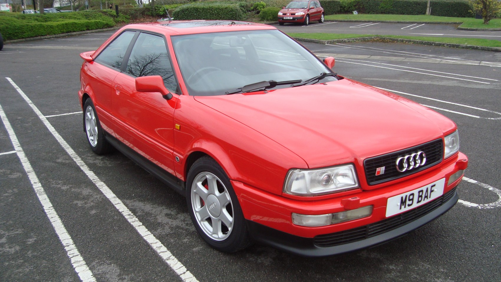 Red coupe with front grille and alloy wheels