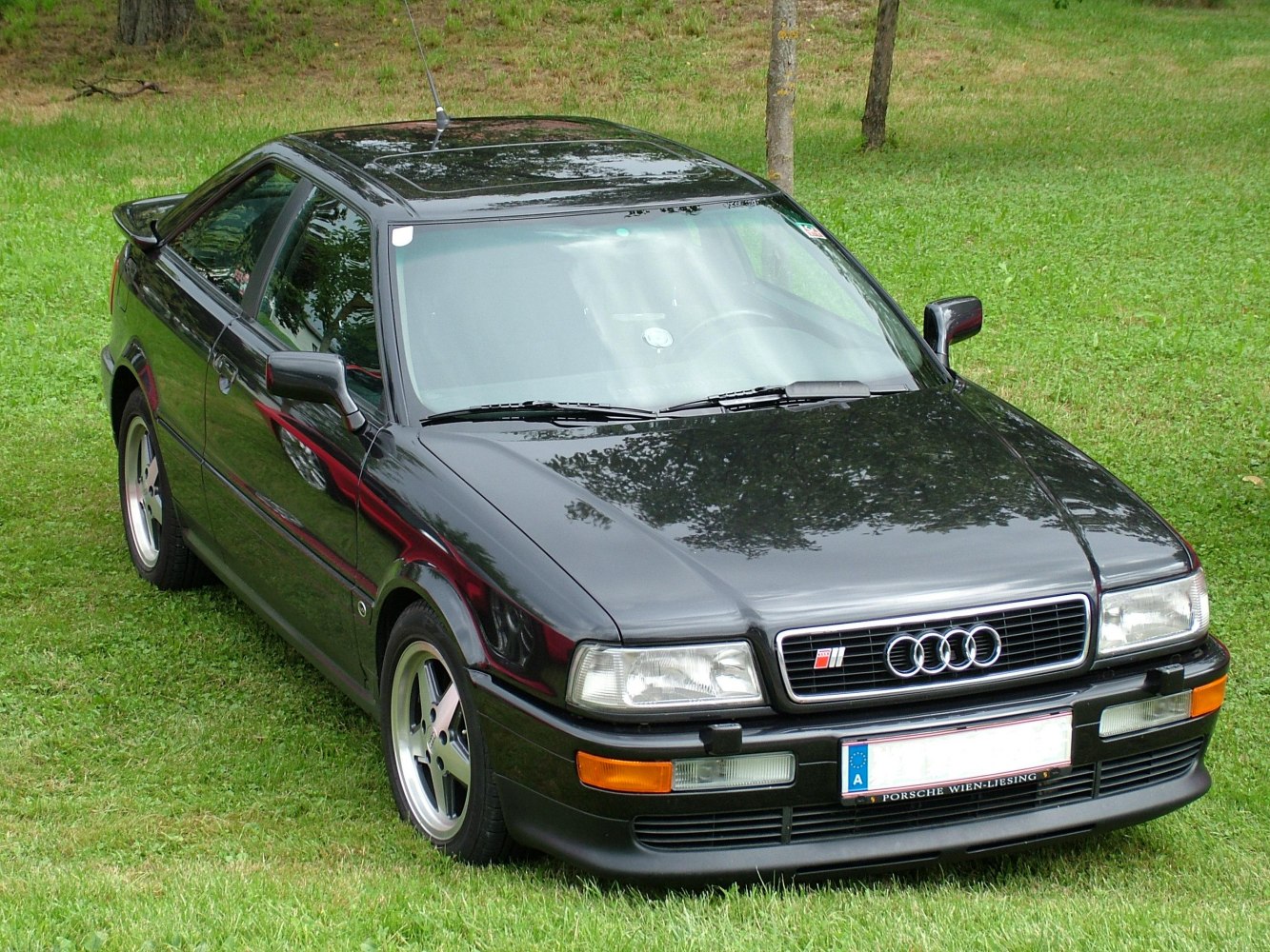 Front three-quarter view of a sporty coupe with sharp headlights and iconic grille