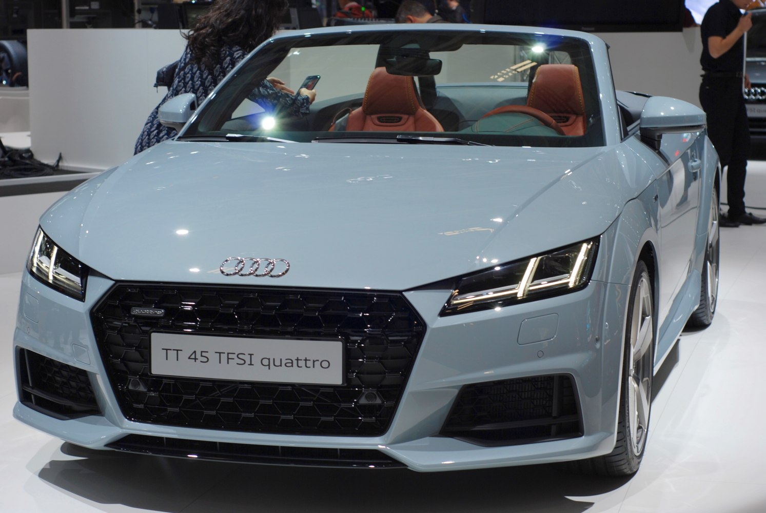 Front view of a convertible sports car with LED headlights and honeycomb grille.