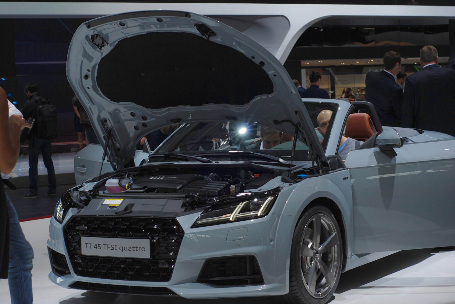 Convertible with open hood revealing engine compartment and front grille