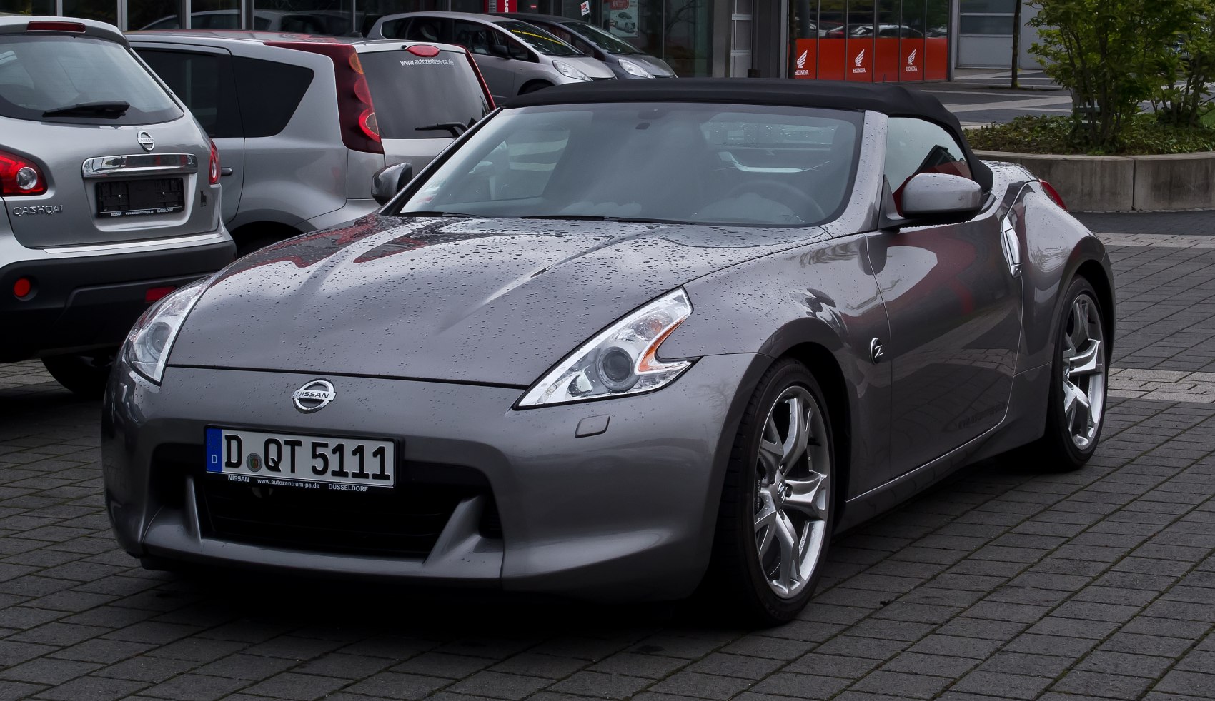 Convertible sports car front with distinct headlights and alloy wheels