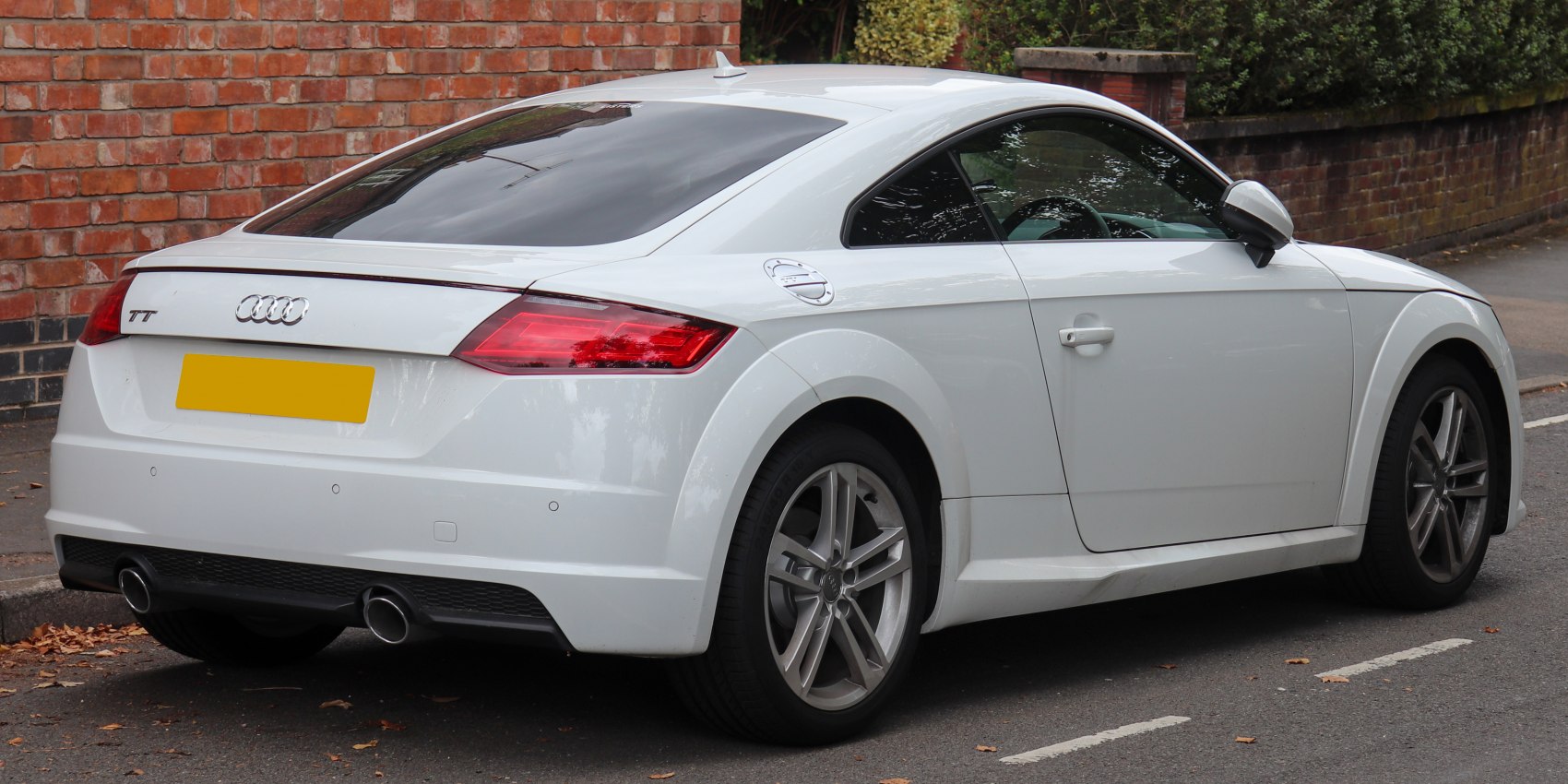 White modern sports coupe rear with dual exhaust and alloy wheels