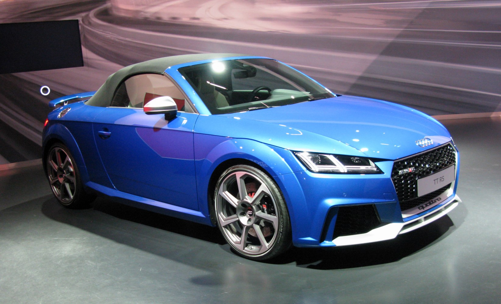 Blue convertible coupe with sporty wheels and aggressive front grille