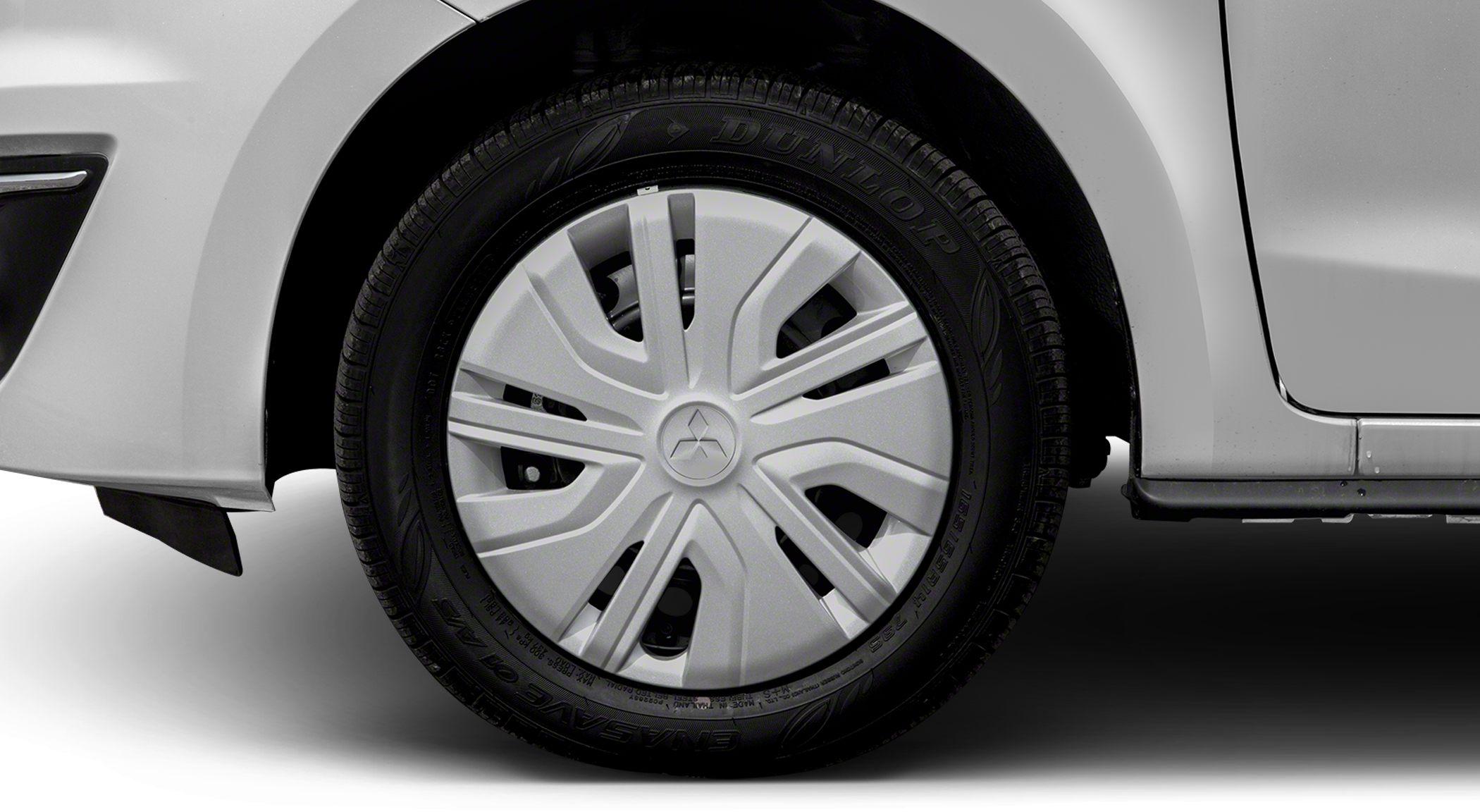 Close-up of a stylish six-spoke hubcap and Dunlop tire on a hatchback wheel