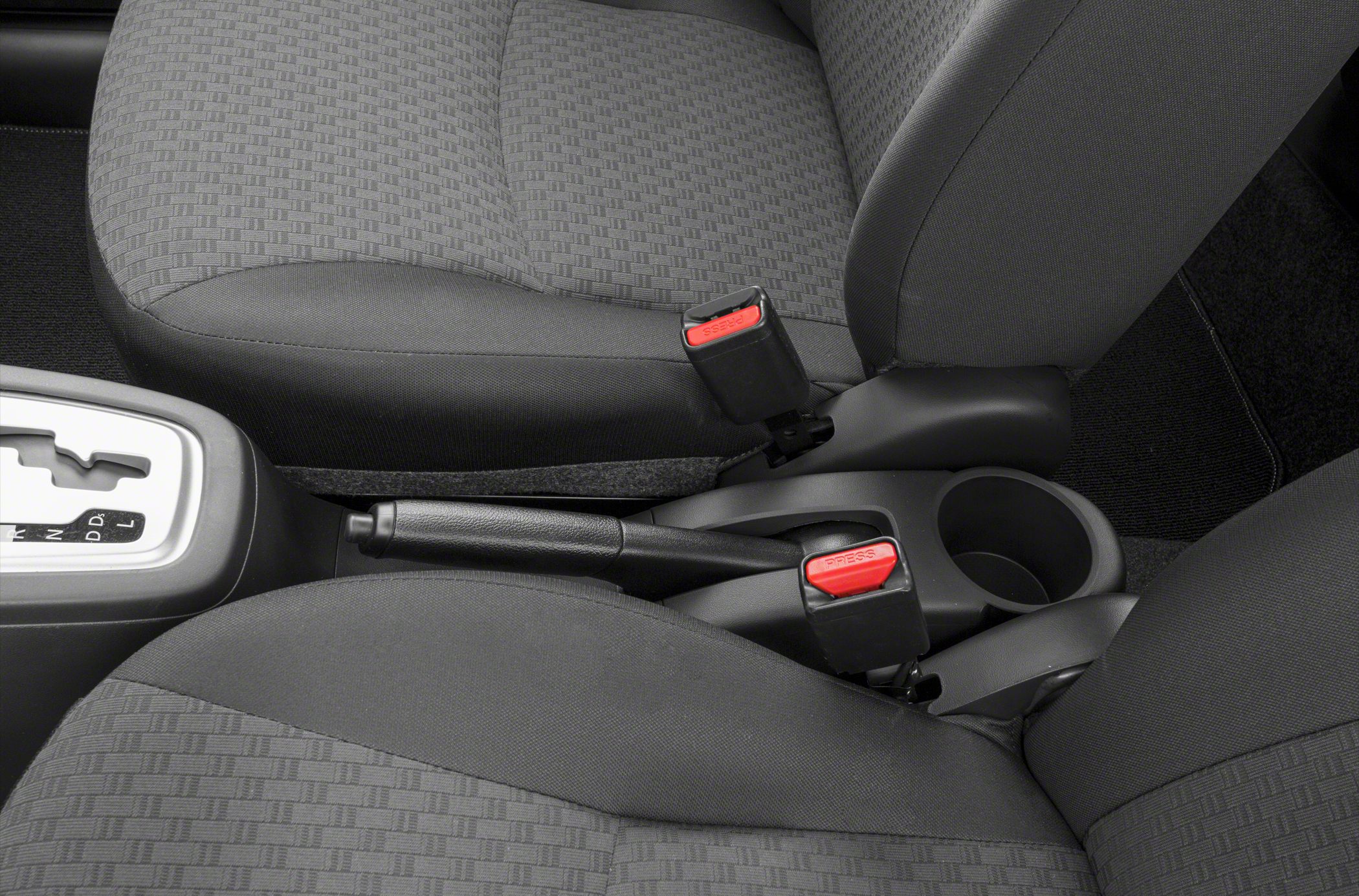 Close-up of seatbelt buckles, handbrake, and gear shifter interior section