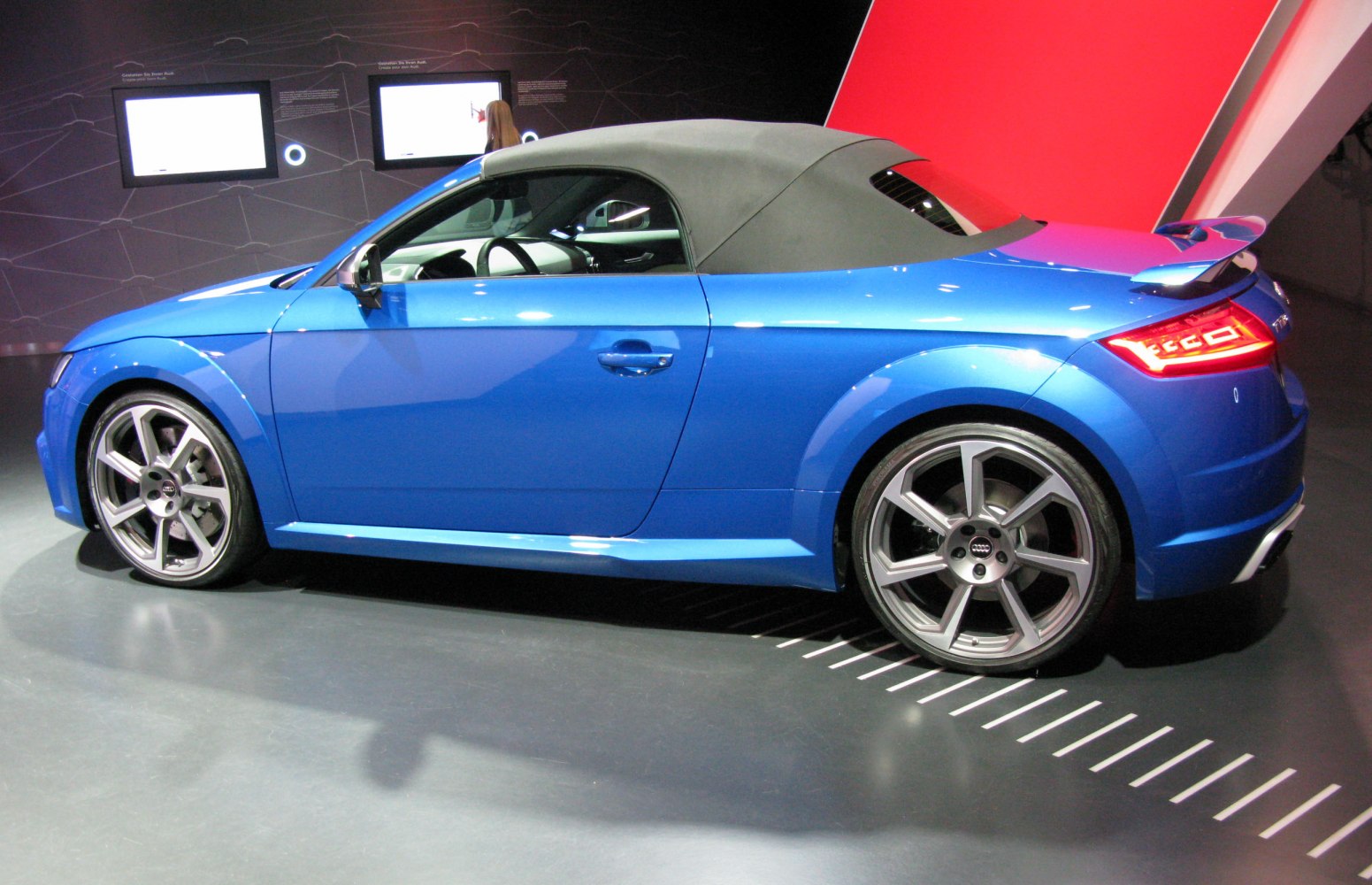 Convertible sports coupe with soft top roof and alloy wheels side view