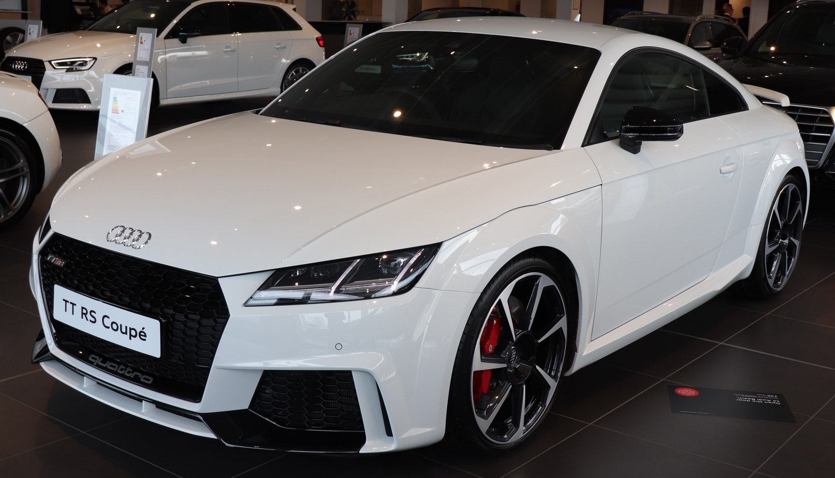 White sports coupe with aggressive front grille and sporty alloy wheels