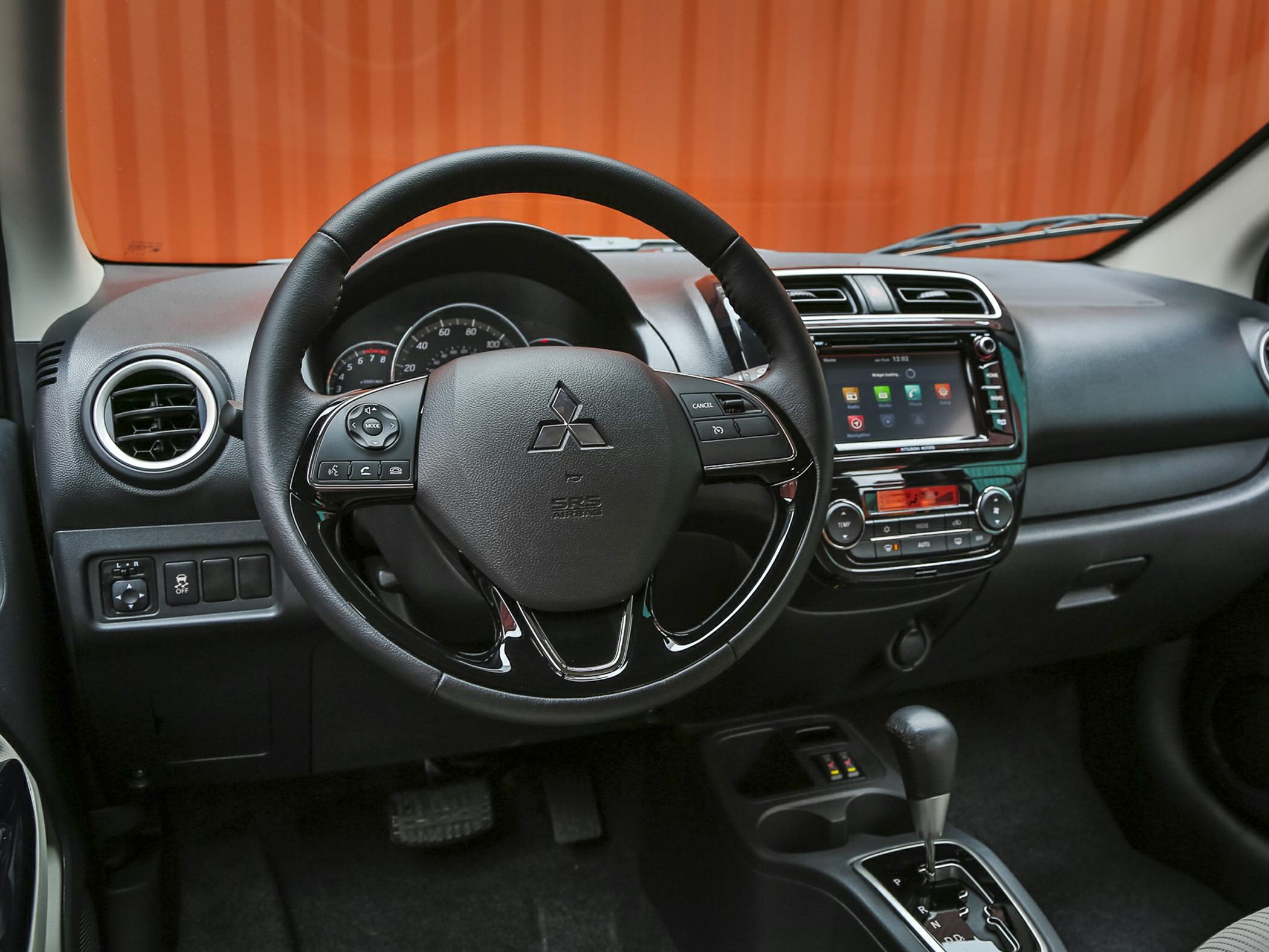 Dashboard, steering wheel, infotainment screen, and gear lever of a car interior