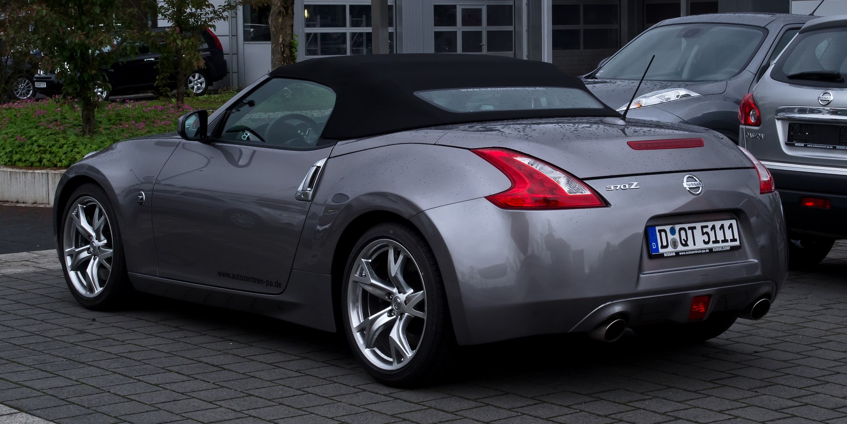Rear-side view of a soft top convertible with distinctive taillights and alloy wheels