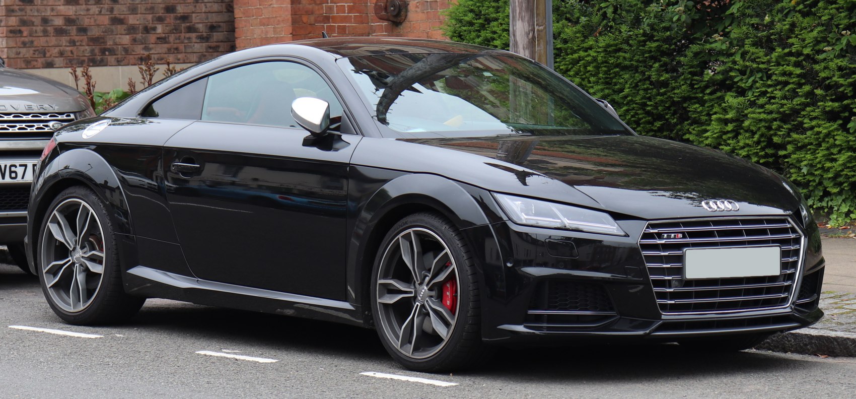 Front and side view of a black sports coupe with distinctive grille and alloy wheels