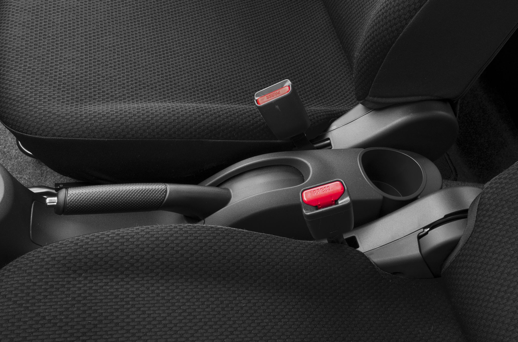 Close-up of hand brake and seatbelt buckles inside car interior