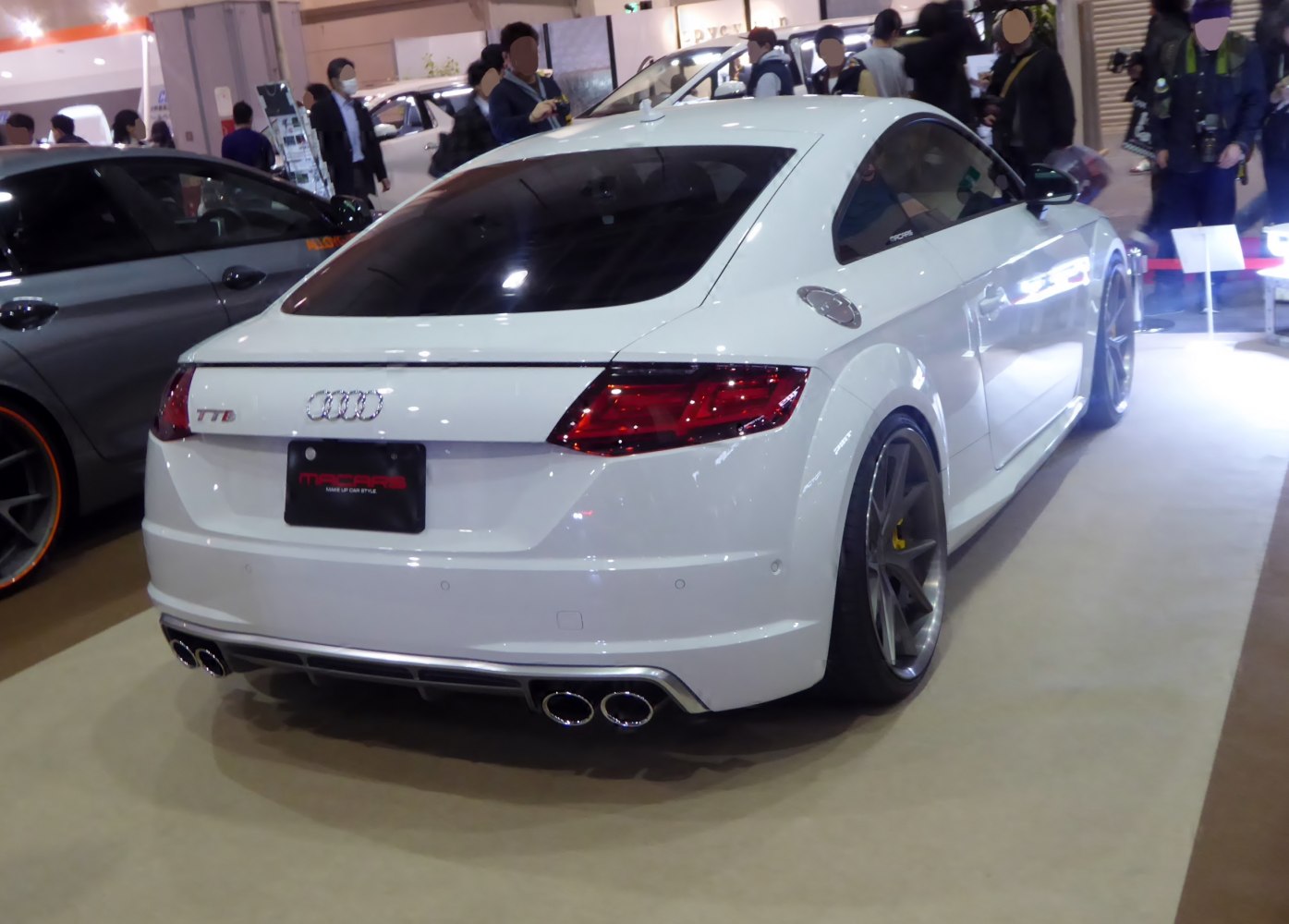 White coupe rear with quad exhausts and sporty tail lights
