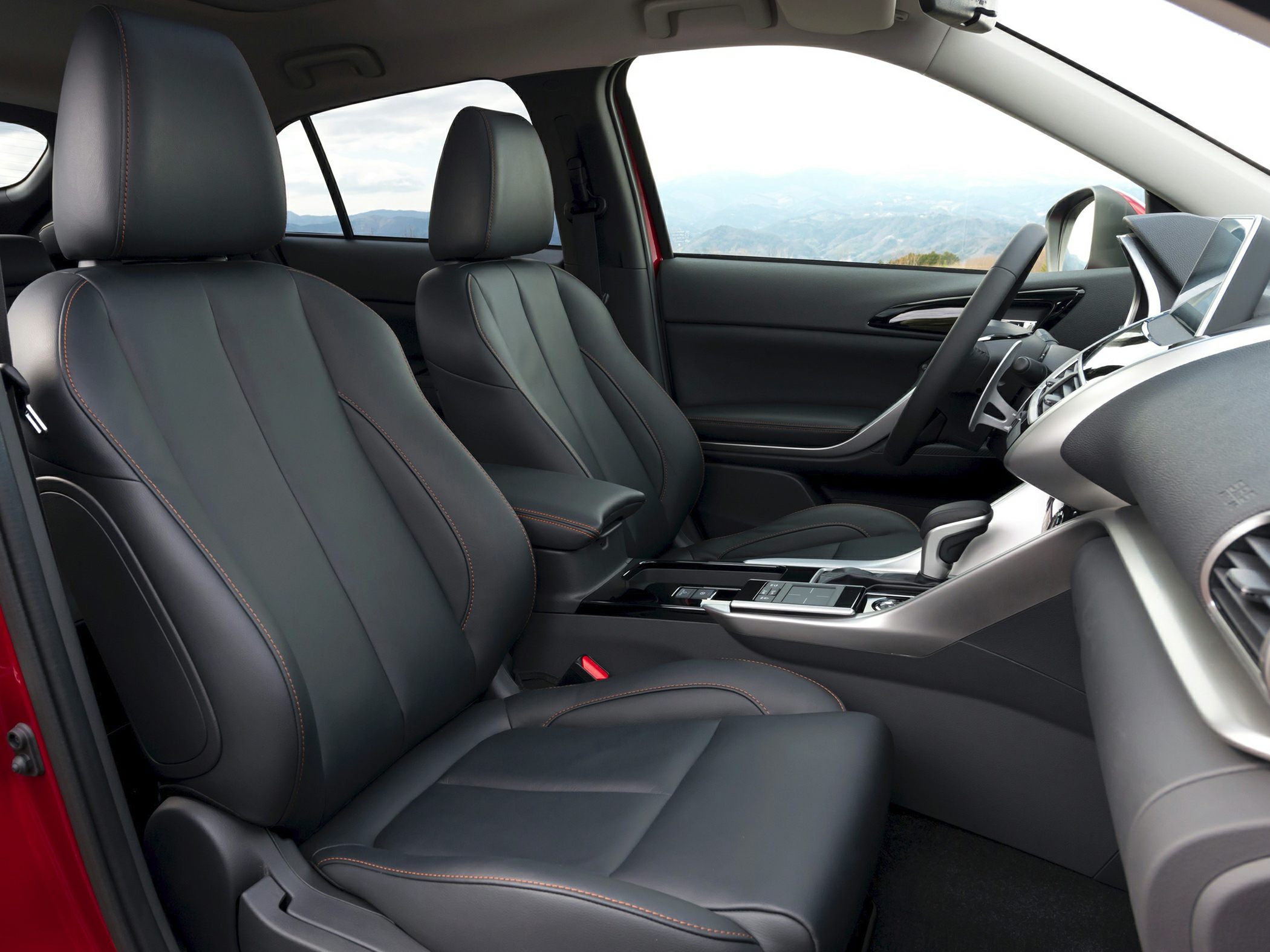 Black leather front seats with orange stitching and modern center console design
